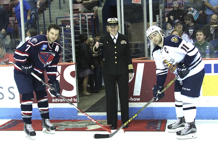 Naval Health Clinic Charleston commanding officer Capt. Elizabeth Maley
prepares to drop the ceremonial first puck between Joey Leach of the South
Carolina Stingrays and Bretton Cameron of the Greenville Swamp Rabbits Feb.
18 at the Coliseum in North Charleston. (Photo by Vin Duffy, South Carolina
Stingrays)  
