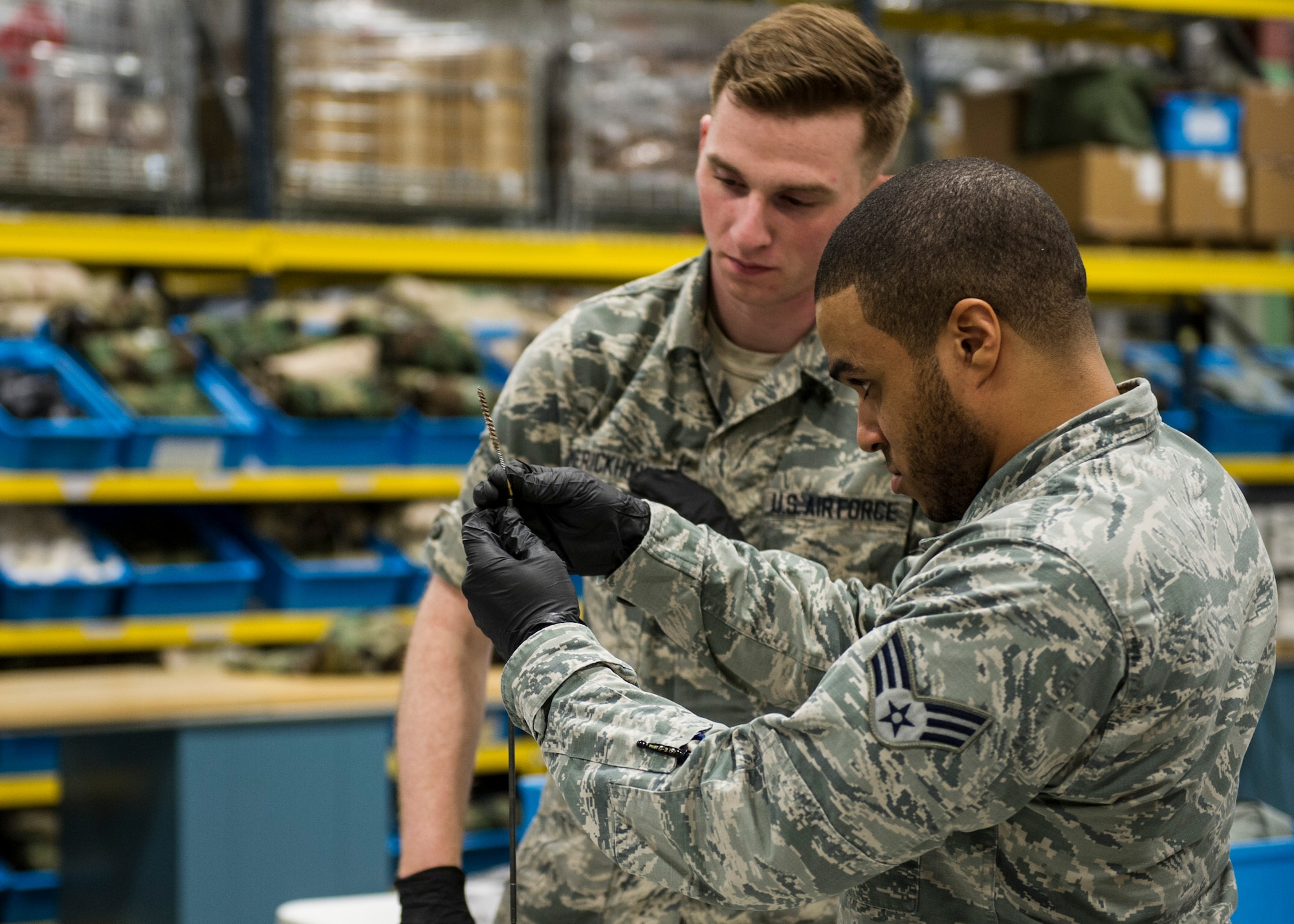 Senior Airman Andrew Gatson, 92nd Logistics Readiness Squadron logistics journeyman, helps Airman 1st Class John Humerickhouse, 92nd LRS petroleum oil lubricant apprentice, assemble an M4 carbine cleaning rod during a gas mask and weapons class Feb. 18, 2016, at Fairchild Air Force Base, Wash. The class goes over safety information. After going over safety information, Airmen are shown how to disassemble, clean and  reassemble the weapon. (U.S. Air Force photo/Airman 1st Class Sean Campbell)