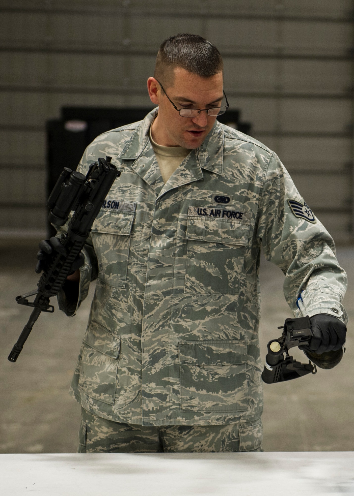 Staff Sgt. Sean Wilson, 92nd logistics Readiness Squadron logistics journeyman, demonstrates dismantling an M4 carbine before cleaning during a gas mask and weapons class Feb. 18, 2016, at Fairchild Air Force Base, Wash. The weapons portion starts by teaching everyone how to clear. (U.S. Air Force photo/Airman 1st Class Sean Campbell)