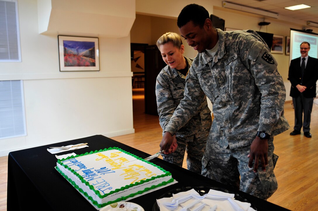U.S. Air Force Col. Caroline M. Miller, commander of the 633rd Air Base Wing, and U.S. Army Pfc. Sergio Barbel, watercraft engineer from the 331st Transportation Company, 11th Transportation Battalion, 7th Sustainment Brigade, cut a cake signifying the beginning of Military Saves Week, at Fort Eustis, Feb. 19, 2016. This year’s theme for the week is “Start Small, Think Big.” (U.S. Air Force photo by Airman 1st Class Breonna Veal)