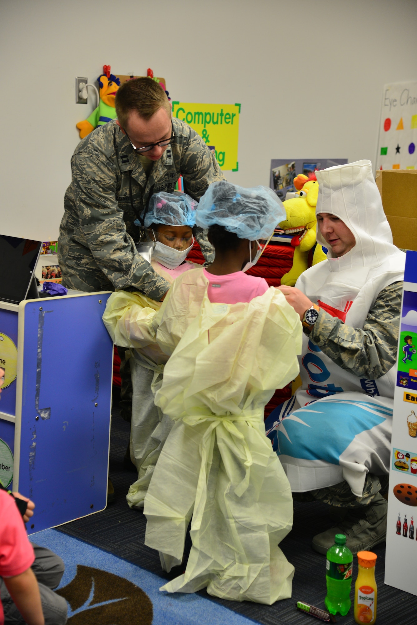 U.S. Airmen assigned to the 633rd Dental Squadron assist children with donning sterile attire typically used at a dentist’s office Langley Air Force Base, Va., Feb. 23, 2016. The dentists used interactive learning to help the children become more comfortable about visiting the dentist. (U.S. Air Force photo by Staff Sgt. Aubrey White)