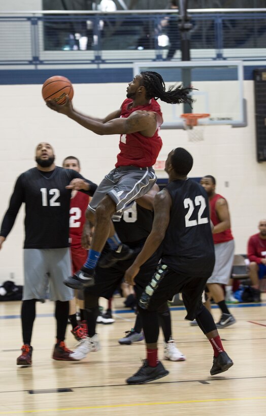 A member of the 633rd Force Support Squadron basketball team attempts a lay-up against a member of the Ryan Center during the Intramural Basketball Championship game at Langley Air Force Base, Va., Feb. 23. 2016. The FSS team went on to beat the Ryan Center with a score of 48 to 45. (U.S. Air Force photo by Senior Airman Kayla Newman)