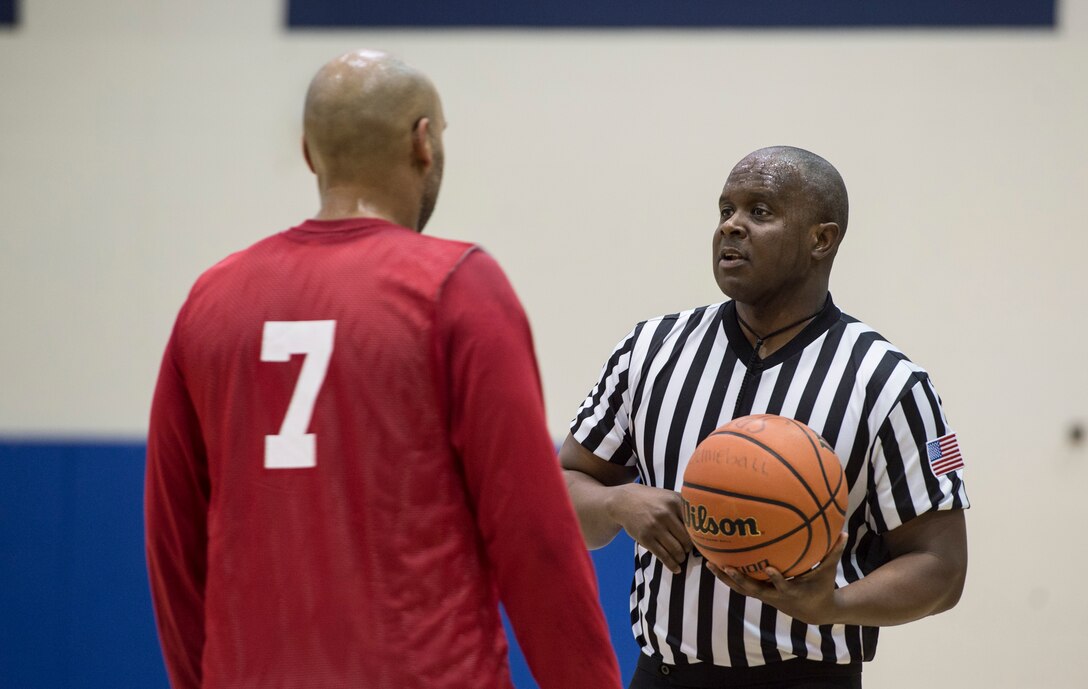 A referee discusses a call with a member of the 633rd Force Support Squadron basketball team during the Intramural Basketball Championship game at Langley Air Force Base, Va., Feb. 23. 2016. The game, played between FSS and the Ryan Center, was officiated by three referees. (U.S. Air Force photo by Senior Airman Kayla Newman)