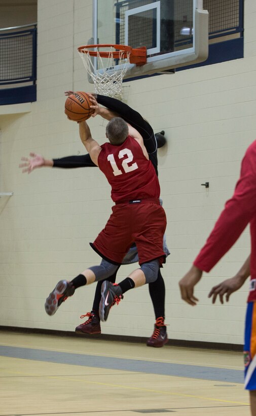 A member of the 633rd Force Support Squadron basketball team goes attempts a lay-up against a member of the Ryan Center during the Intramural Basketball Championship game at Langley Air Force Base, Va., Feb. 23. 2016. The FSS team finished the season as the top seeded team before heading into the championship game. (U.S. Air Force photo by Senior Airman Kayla Newman)