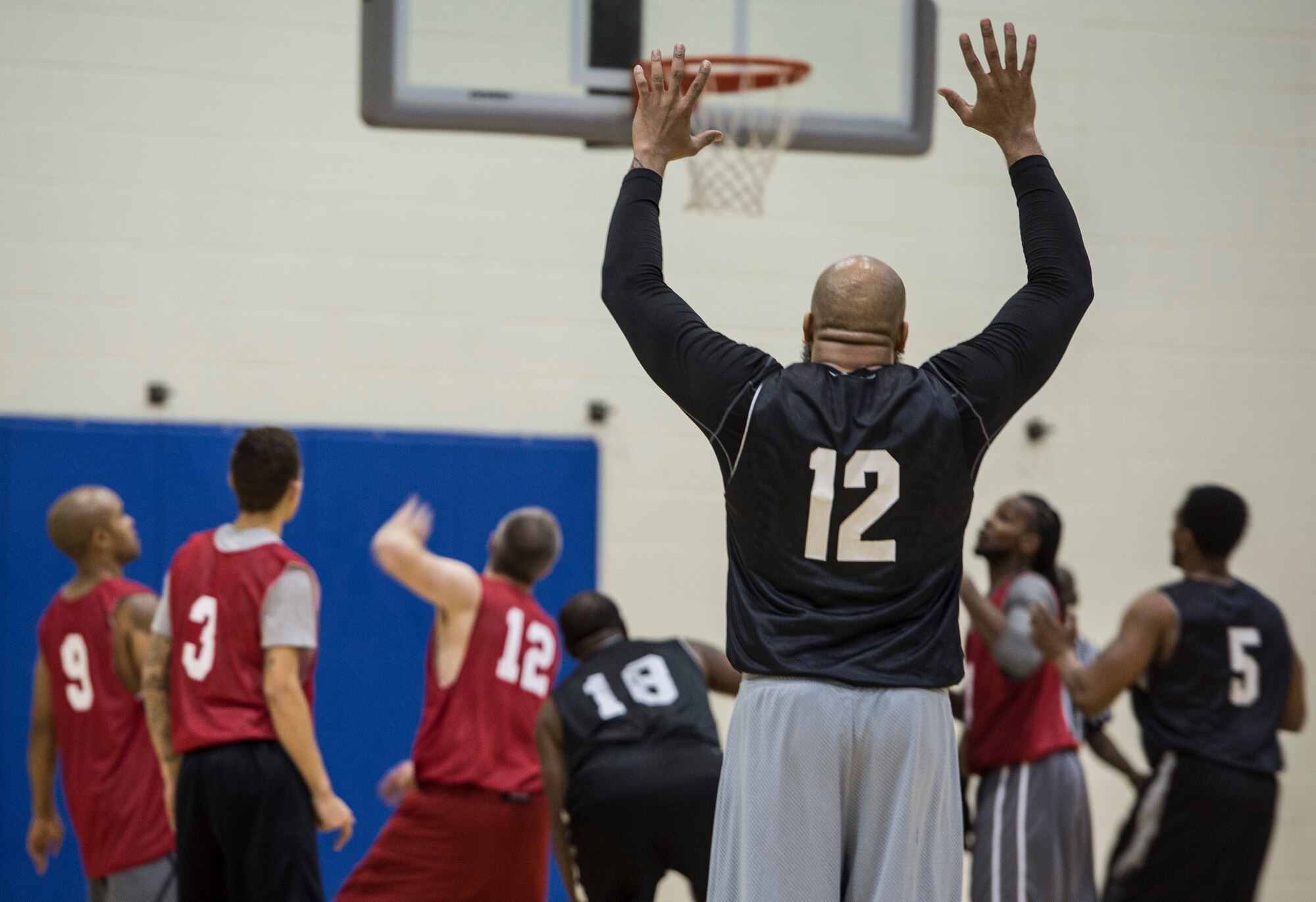 A member of the Ryan Center basketball team signals for the basketball during the Intramural Basketball Championship game at Langley Air Force Base, Va., Feb. 23. 2016. The Ryan Center finished as the third-seeded team before making it to the championship game. (U.S. Air Force photo by Senior Airman Kayla Newman) 
