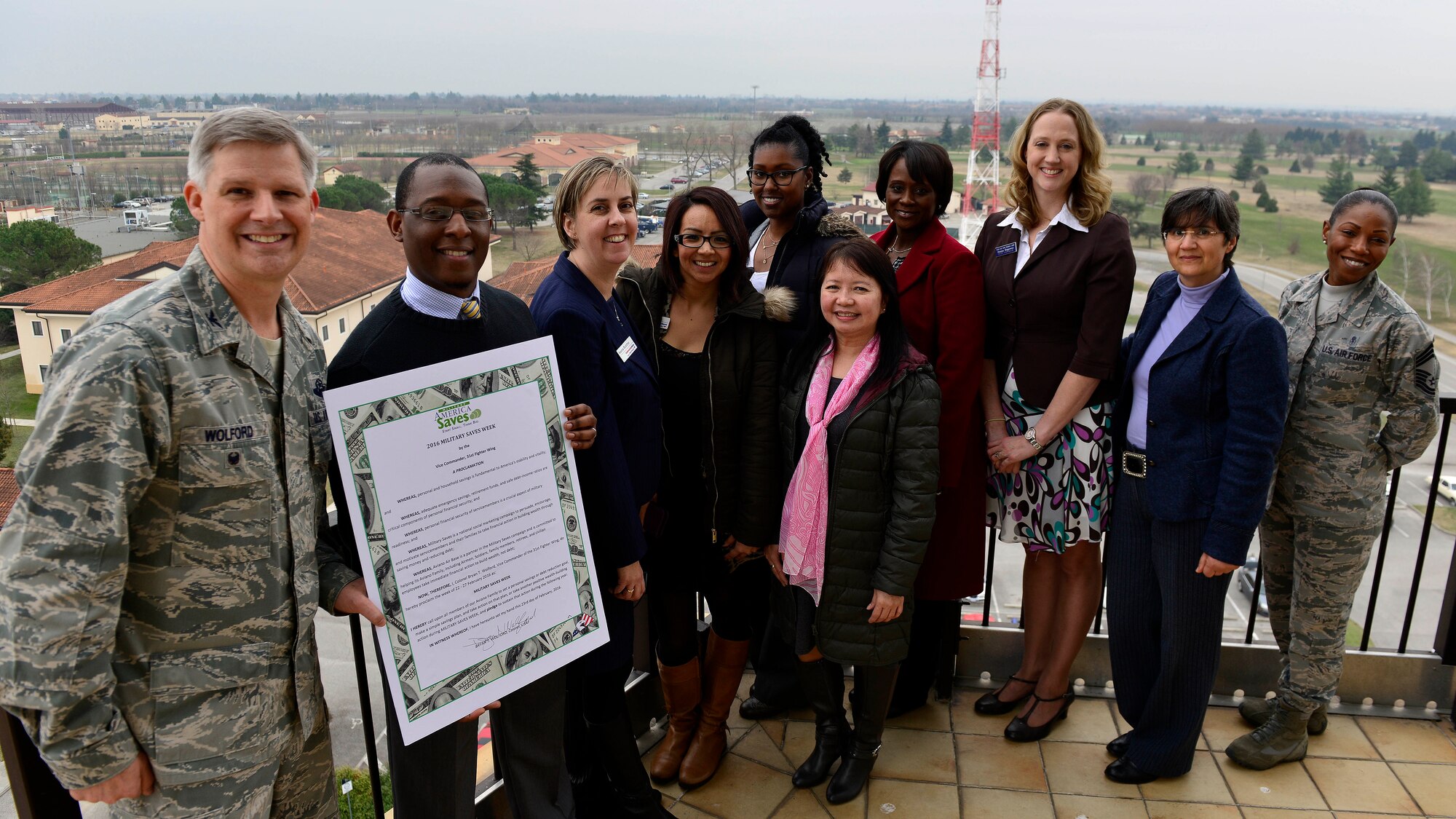 The 31st Fighter Wing leaders, Airman and Family Readiness Center personnel and local bank representatives, present the signed Military Saves Week proclamation, Feb. 23, 2016, at Aviano Air Base, Italy. Military Saves Week aims to motivate, support and encourage military families to save money, reduce debt, and build wealth. (U.S. Air Force photo by Airman 1st Class Cary Smith/Released)