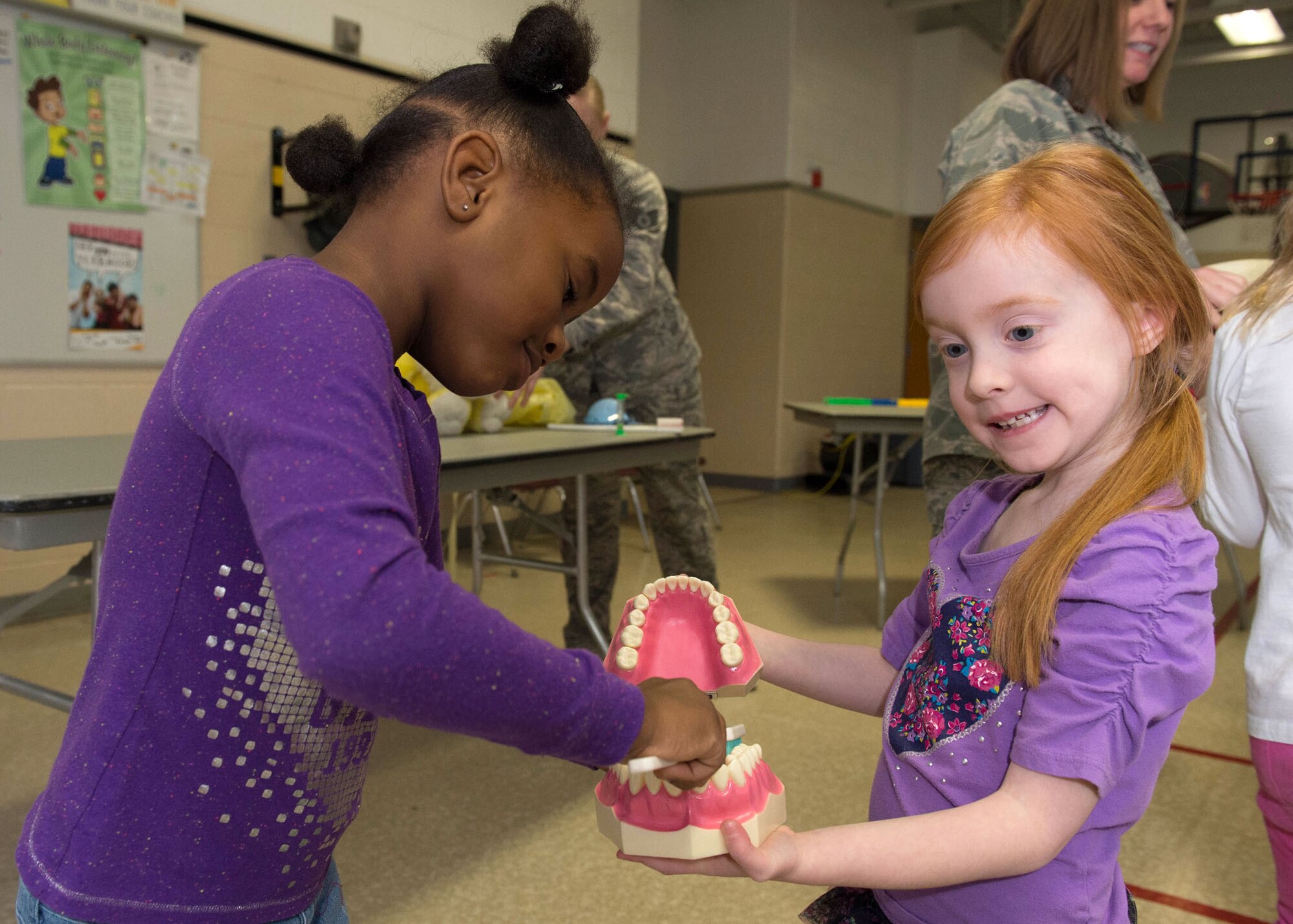 Kindergarteners Trinity Bien-Aime and Eire Lyn Bincarousky practice brushing teeth at the Hanscom Primary School Feb. 24. The students received a lesson in brushing teeth from 66th Medical Squadron dental personnel as part of National Children's Dental Health Month. (U.S. Air Force photo by Jerry Saslav)