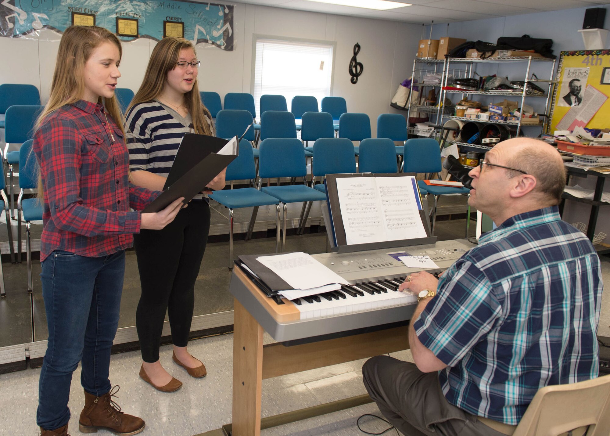 Hanscom Middle School students, Leah Paxton, center, and Stacie Woolley, practice music selections with Howard Worona, HMS music director, at the middle school Feb. 22. The students were selected to perform at the Massachusetts Music Educators Association Eastern District Junior Festival scheduled March 4 and 5 at nearby Lincoln-Sudbury Regional High School. Both will sing in Treble Choir and will sing soprano with the ensemble. (U.S. Air Force photo by Jerry Saslav)