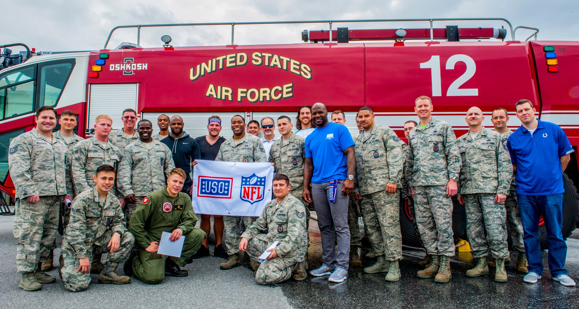 Members of the Indianapolis Colts and the 18th Civil Engineer Squadron take a group photo during the Colts visit to Kadena Air Base, Japan, Feb. 19, 2016. The USO hosted the Indianapolis Colts visit to Kadena to speak with Airmen at four locations on base, including a dinner with the troops at the Marshal Dining Facility. (U.S. Air Force photo by Airman 1st Class Nick Emerick)