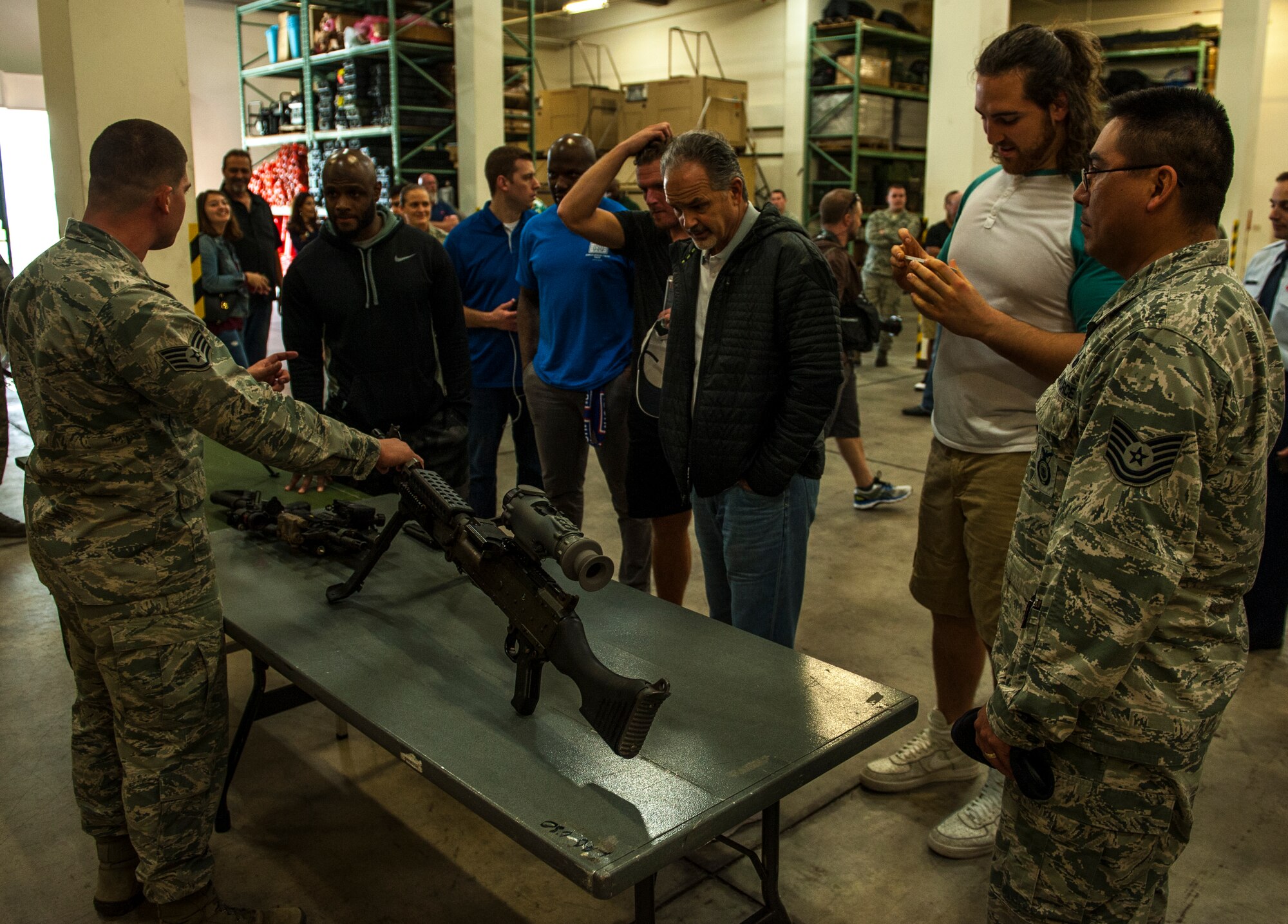Members of the Indianapolis Colts receive a brief on some of the weapons used by the 18th Security Forces Squadron by Staff Sgt. Michael Starkovich, 18th SFS armory NCO in charge, Feb. 19, 2016, at Kadena Air Base, Japan. The Indianapolis Colts toured Kadena, spoke with Airmen and learned about their jobs and everyday life. (U.S. Air Force photo by Airman 1st Class Nick Emerick) 