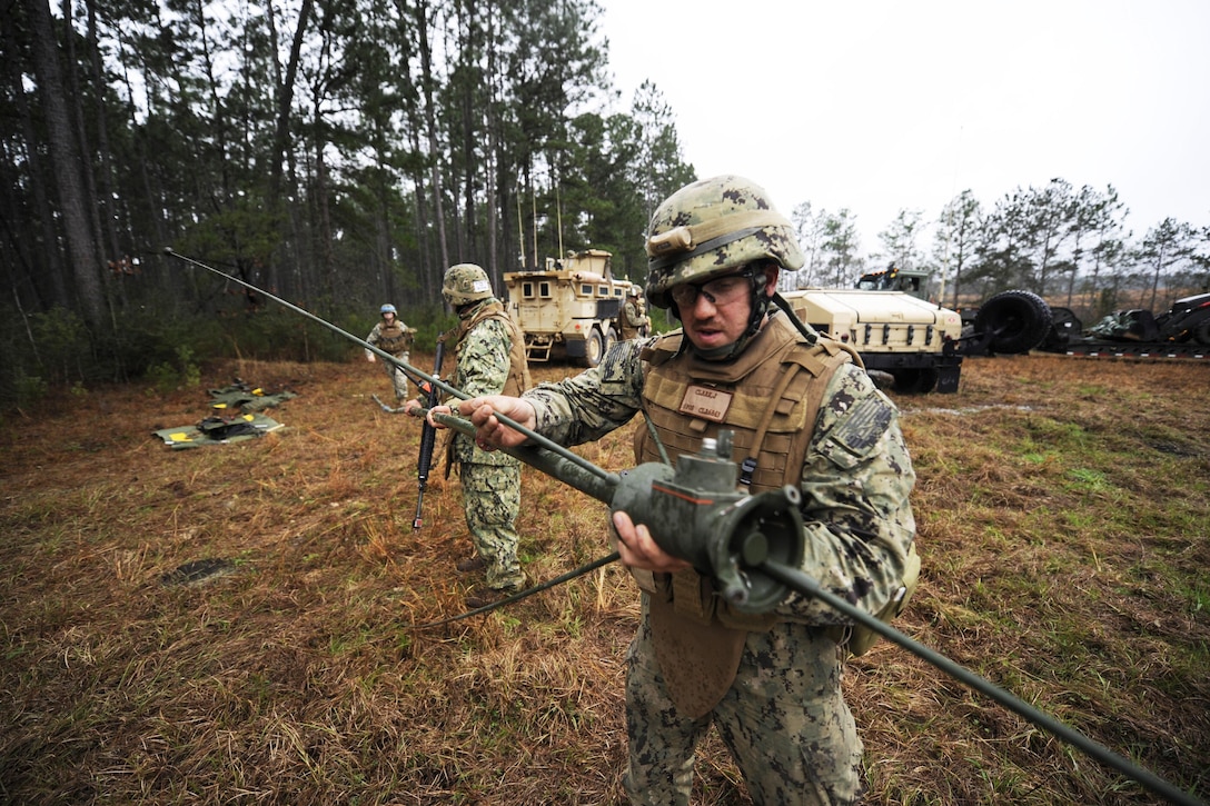 Navy Petty Officer 2nd Class Jacob Clark sets up communications equipment during field training exercises at Camp Shelby, Miss., Feb. 22, 2014. Clark is assigned to Naval Mobile Construction Battalion 11. Navy photo by Petty Officer 1st Class Michael C. Barton