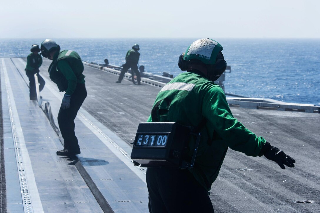 Sailors place a slot seal into the rail of a catapult on the flight deck of the aircraft carrier USS John C. Stennis after a launch and recovery cycle during training in the Philippine Sea, Feb. 23, 2016. U.S. Navy photo by Petty Officer 3rd Class Kenneth Rodriguez Santiago