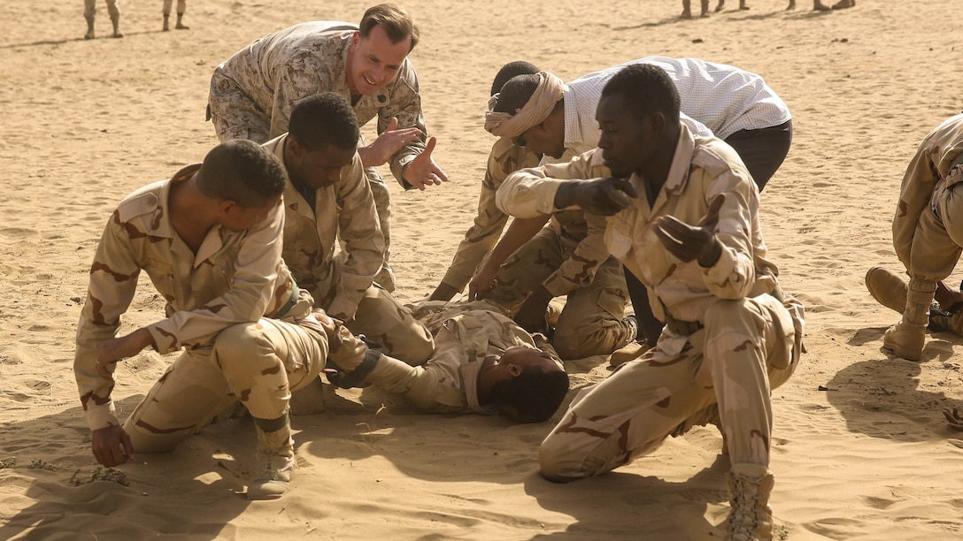Staff Sgt. Todd Reinert, a motor transportation operations chief, guides soldiers through treating a casualty under fire during training in Tiguent, Mauritania, Jan. 19, 2016. Marines and sailors with the Special-Purpose Marine Air-Ground Task Force Crisis Response-Africa trained with the Mauritanian Logistics Battalion for five weeks to assist in building its capacity to counter terrorism and provide sovereign security. 