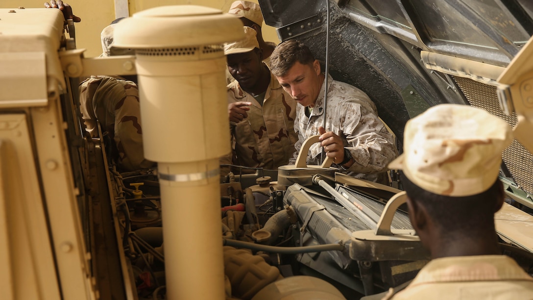 Cpl. Josh Sizelove, a motor transportation mechanic, describes parts of a Humvee engine to Mauritanian mechanics during training in Tiguet, Mauritania, Jan. 27, 2016. Marines and sailors with the Special-Purpose Marine Air-Ground Task Force Crisis Response-Africa trained with the Mauritanian Logistics Battalion for five weeks to assist in building its capacity to counter terrorism and provide sovereign security. 