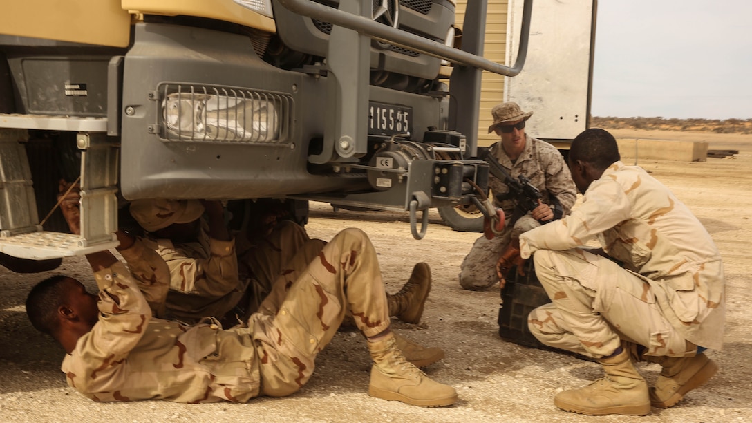 Cpl. Josh Sizelove, a motor transportation mechanic, advises soldiers as they fix a downed truck during a convoy operation exercise in Tiguet, Mauritania, Feb. 12, 2016. Marines and sailors with the Special-Purpose Marine Air-Ground Task Force Crisis Response-Africa trained with the Mauritanian Logistics Battalion for five weeks to assist in building its capacity to counter terrorism and provide sovereign security. 