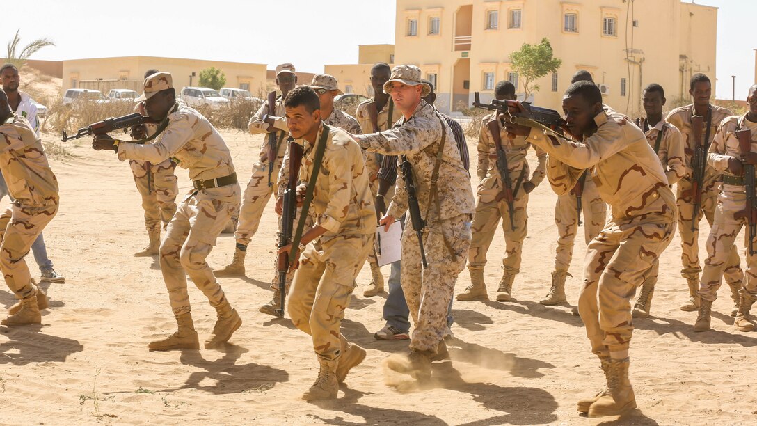 Staff Sgt. Todd Reinert, a motor transportation operations chief, guides soldiers through shooting drills prior to a live-fire range in Tiguet, Mauritania, Feb. 15, 2016. Marines and sailors with the Special-Purpose Marine Air-Ground Task Force Crisis Response-Africa trained with the Mauritanian Logistics Battalion for five weeks to assist in building its capacity to counter terrorism and provide sovereign security.