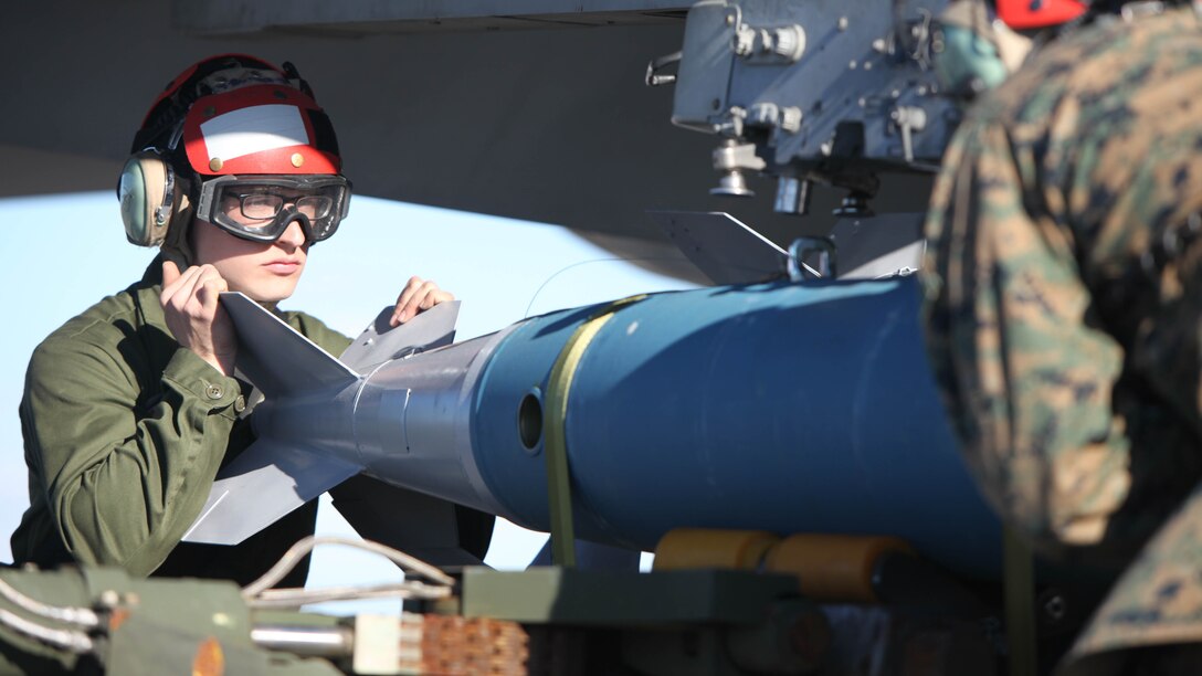 Lance Cpl. Stephen Tryen assists in lifting a BDU-45 practice bomb onto an F/A-18 Hornet during Exercise Coastal Predator at Marine Corps Air Station Cherry Point, N.C., Feb. 16, 2016. The practice bomb falls according to the trajectory of the aircraft while in flight and is used for training purposes. Coastal Predator is an exercise that included Marine Corps and Army aviation assets along with Air Force personnel and civilian contractors to conduct Forward Air Controller Airborne training in accordance with the pre-deployment training program. Tryen is an ordnance technician with Marine All Weather Fighter Attack Squadron 533. 