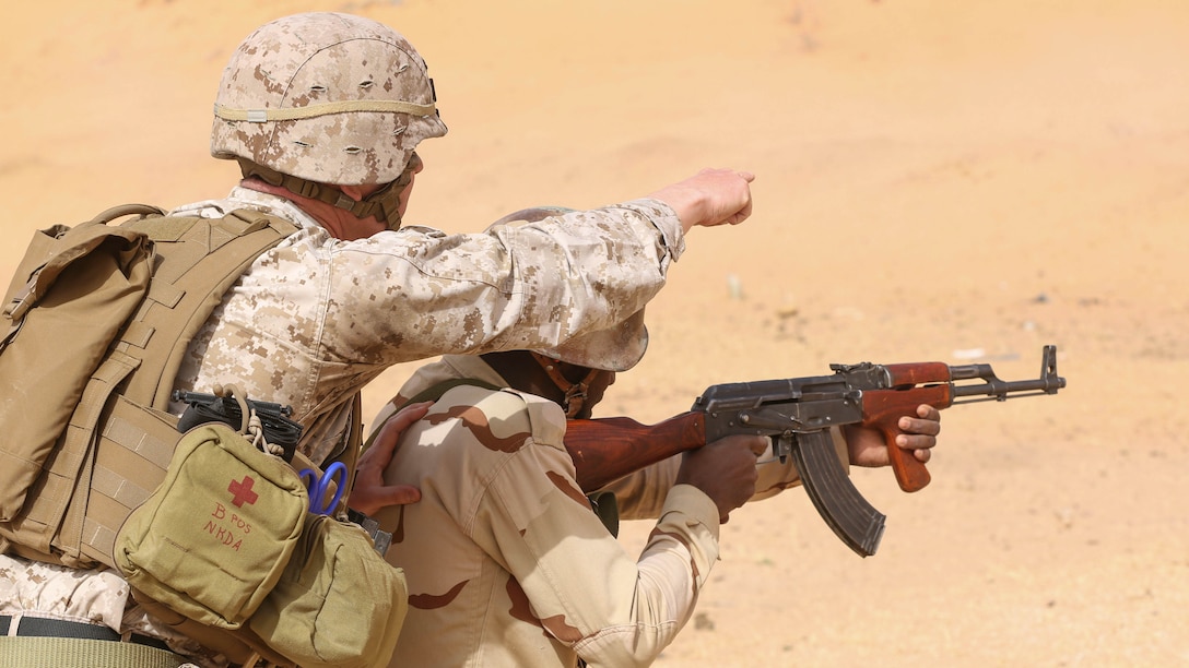 Staff Sgt. Todd Reinert, a motor transportation operations chief, guides a soldier through a shooting drill during training in Tiguet, Mauritania, Feb. 16, 2016. Marines and sailors with the Special-Purpose Marine Air-Ground Task Force Crisis Response-Africa trained with the Mauritanian Logistics Battalion for five weeks to assist in building its capacity to counter terrorism and provide sovereign security. 
