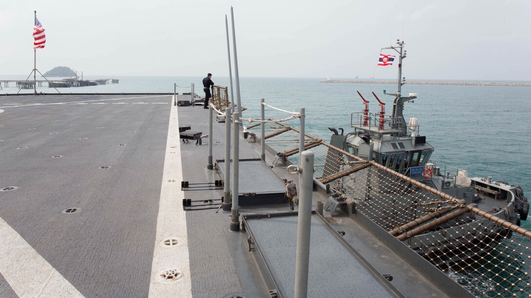 The USS Ashland is pulled by a Thai tug boat as it departs from the Port of Sattahip, Thailand, Feb. 21, 2016. Leaving ended the 31st Marine Expeditionary Unit's involvement in Cobra Gold 16, an annual exercise that increases cooperation, interoperability and collaboration among partner nations in order to achieve effective solutions to common challenges. 