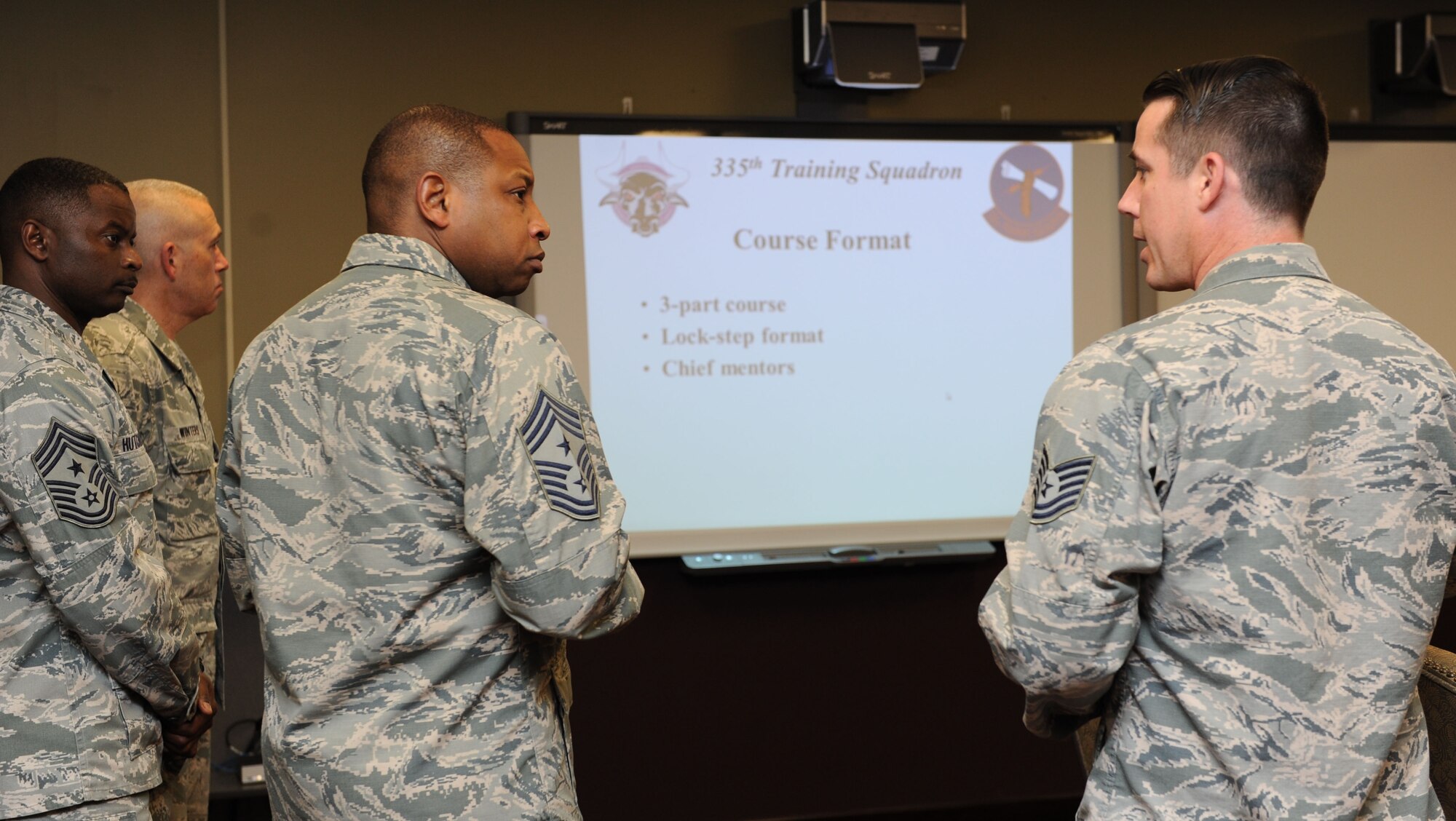 Chief Master Sgt. Farrell Thomas, 2nd Air Force command chief, receives a briefing from Tech. Sgt. Andrew Camp, 335th Training Squadron instructor supervisor, on the advanced weather manager’s course at the weather complex during Thomas’ immersion tour Feb. 22, 2016, Keesler Air Force Base, Miss. He visited the 81st Training Wing to become oriented with group missions, operations and personnel.  (U.S. Air Force photo by Kemberly Groue)

