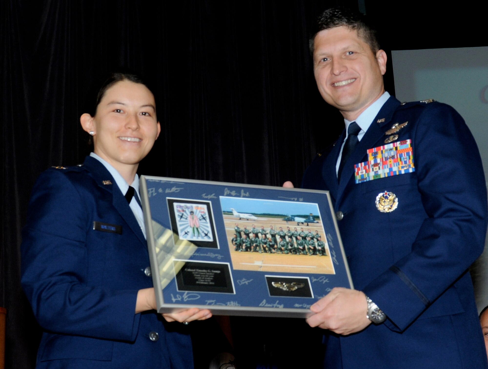 Capt. Jennifer Walters, Specialized Undergraduate Pilot Training Class 16-05 graduate, hands Col. Timothy Sumja, 23rd Fighter Group Commander and guest speaker, a framed class picture Feb. 19 at Columbus Air Force Base, Mississippi. Sumja took the time to describe his experiences in the U.S. Air Force and what kind of deployments and sorties he went through during his speech. (U.S. Air Force photo/Melissa Doublin) 