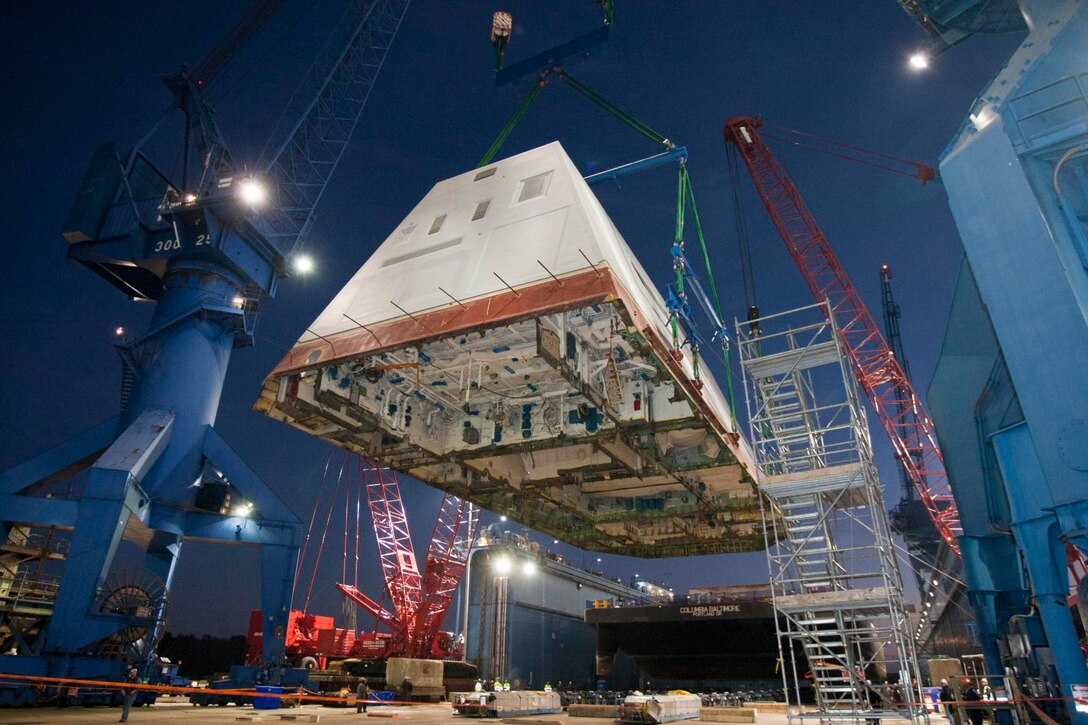 BATH , Maine (Dec. 14, 2012) The 1,000-ton deckhouse of the future destroyer USS Zumwalt (DDG 1000) is craned toward the deck of the ship to be integrated with the ship's hull at General Dynamics Bath Iron Works. The ship launch and christening are planned in 2013. (U.S. Navy photo/Released)