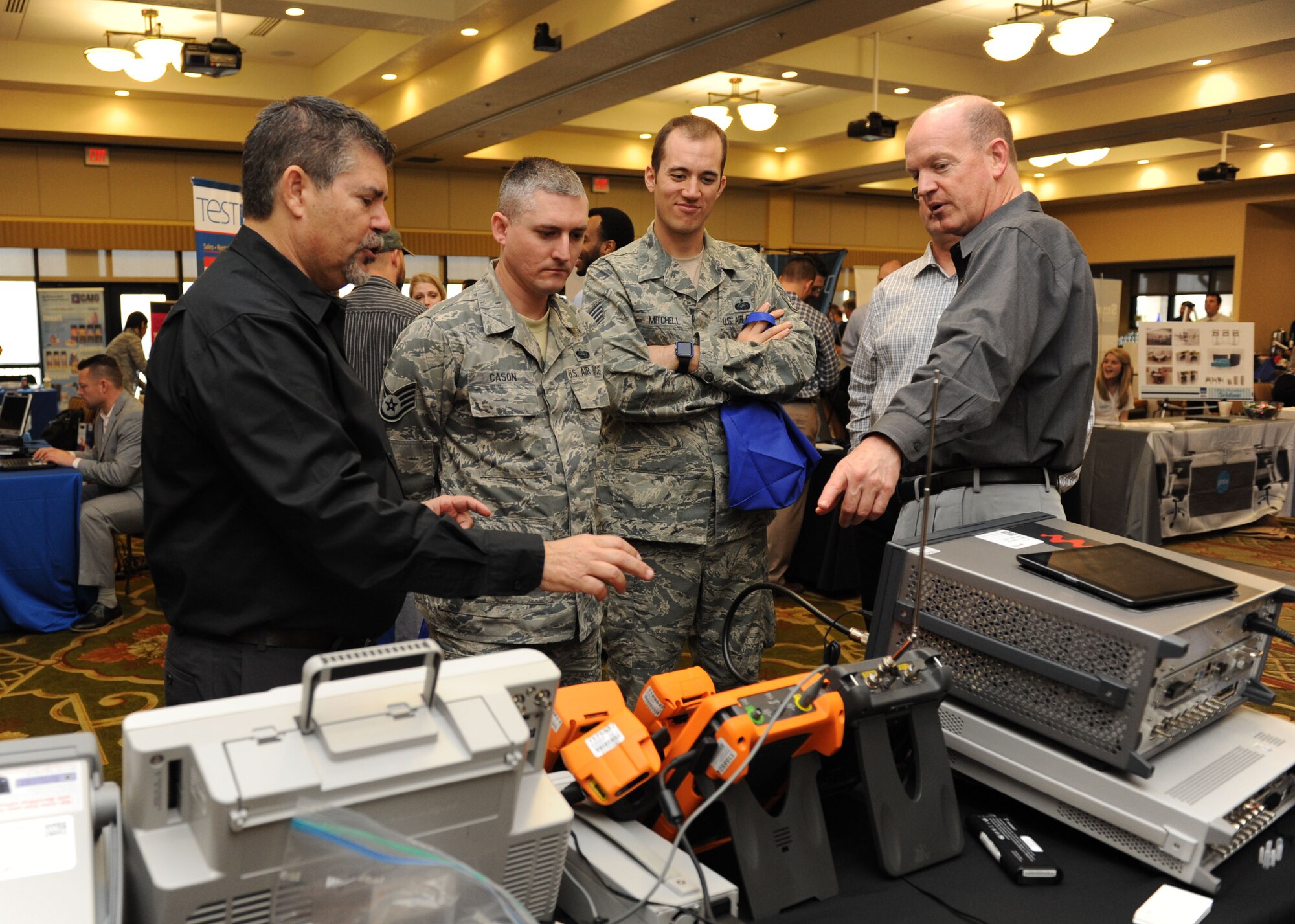 Staff Sgts. Casey Cason and Joseph Mitchell, 338th Training Squadron instructors, are briefed on electronic test and measurement equipment by Miguel Alonso and Phillip Stallcup during the 21st annual Technology Expo at the Bay Breeze Event Center Feb. 23, 2016, Keesler Air Force Base, Miss. The 81st Communications Squadron hosted the event and attendance was free to all Defense Department, government and contractor personnel with base access. (U.S. Air Force photo by Kemberly Groue)