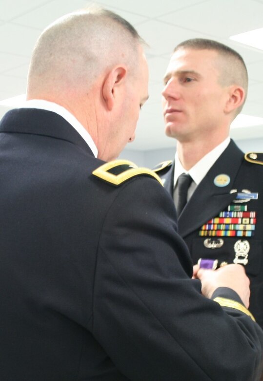 Brig. Gen. Daniel Christian, commanding general of the 95th Training Division (IET) at Fort Sill, Okla., pins a Purple Heart on Sgt. 1st Class Joshua Clark, senior drill sergeant with the 1/330th Infantry Regiment stationed in Fort Wayne, Ind., during a ceremony here Feb. 7. (Photo by Capt. Adrienne Bryant)