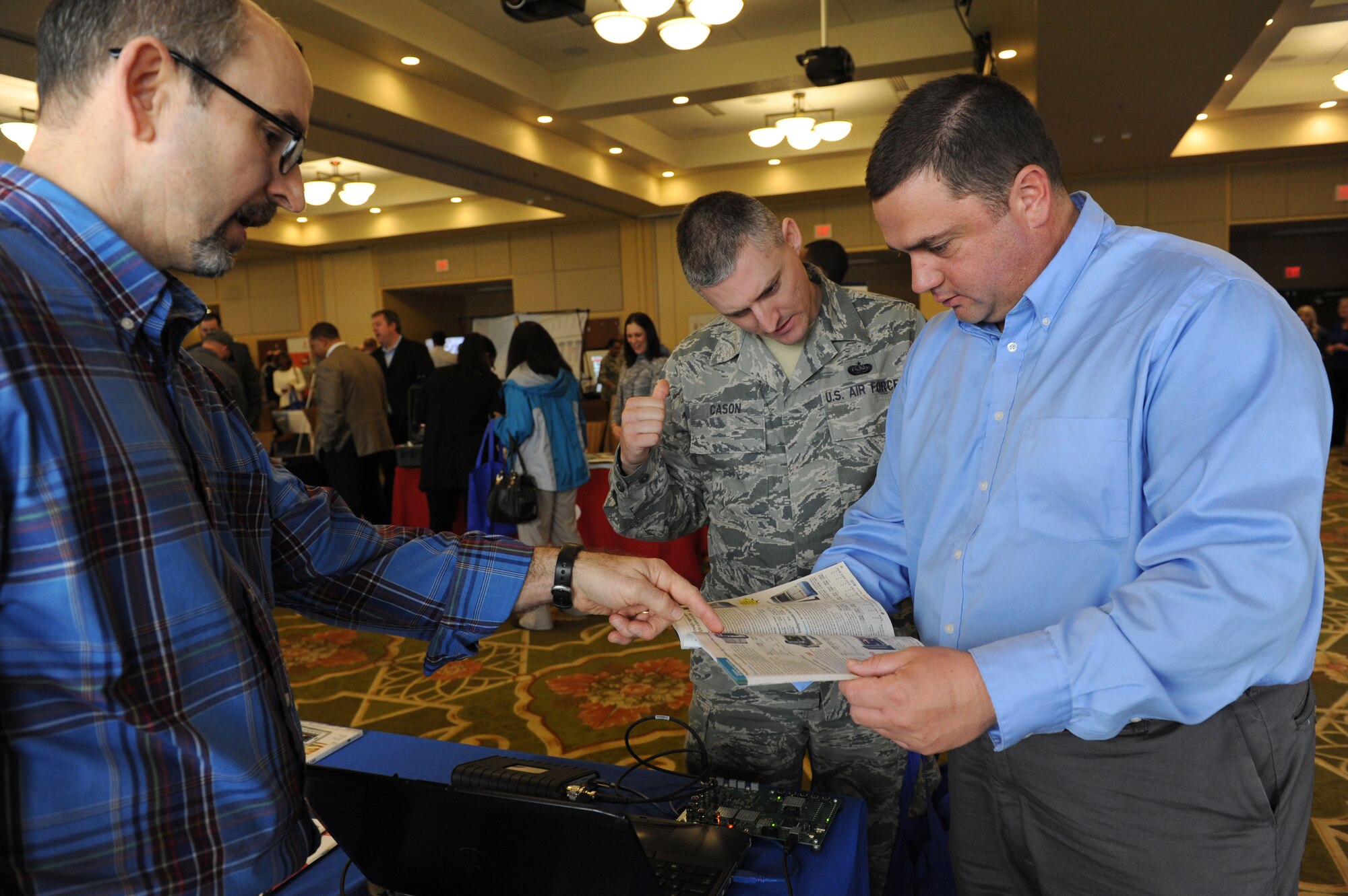 Kelly Cox helps Mark Guice and Staff Sgt. Casey Cason, 338th Training Squadron instructors, research information about spectrum analyzers during the 21st annual Technology Expo at the Bay Breeze Event Center Feb. 23, 2016, Keesler Air Force Base, Miss. The 81st Communications Squadron hosted the event and attendance was free to all Defense Department, government and contractor personnel with base access. (U.S. Air Force photo by Kemberly Groue)