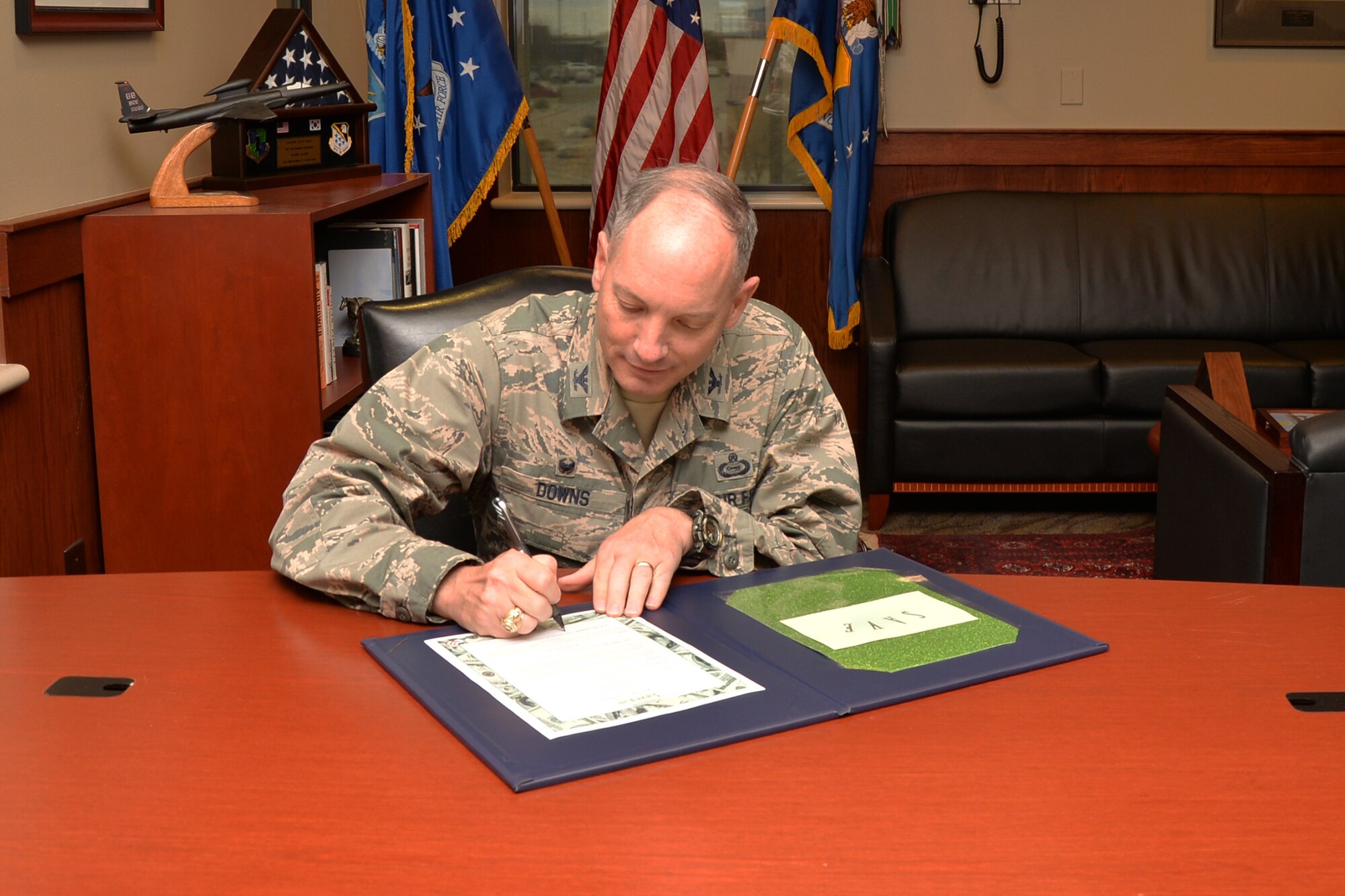 U.S. Air Force Col. Michael L. Downs, 17th Training Wing Commander, signs a proclamation to start off the Military Saves Campaign on Goodfellow Air Force Base, Texas, Feb. 22, 2016. The MSC is an initiative designed to educate service members and their families on the power of saving and setting financial goals. (U.S. Air Force photo by Airman 1st Class Randall A. S. Moose/Released)