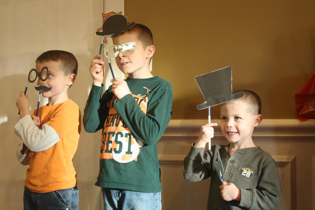 Military children Ryan, 7, Daniel, 8, and Tyler, 3, enjoy posing with props at a photo booth at a FOCUS on Family event Feb. 18.