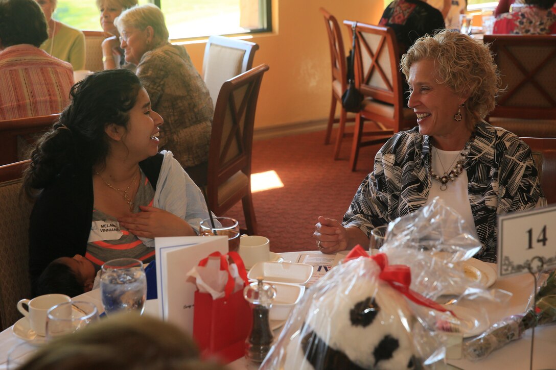 Laurie Craparotta, wife of Maj. Gen. Lewis A. Craparotta, Combat Center Commanding General, shares a laugh with Melanie Vinniane, wife of Sgt. Terrel Vinniane, motor transportation mechanic, 3rd Light Armored Reconnaissance Battalion, during the Assistance League of Palm Springs Desert Area Baby Shower Luncheon for Combat Center expectant mothers at the Oasis Country Club in Palm Desert, Calif., Feb. 16, 2016. (Official Marine Corps Photo by Cpl. Julio McGraw/Released)