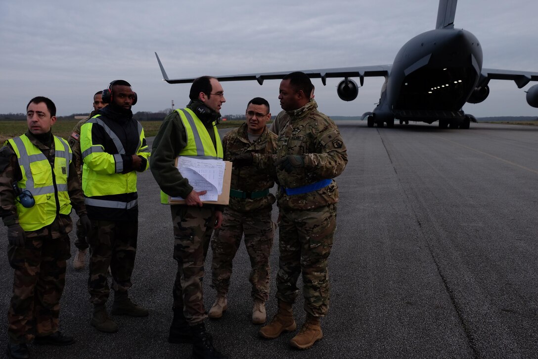 French Air Force movement control team members, left,  and 7th Mission Support Command Soldiers, U.S. Army Reserve Sgt. 1st Class Joaquin Rendon, center, the noncommissioned officer in charge and joint inspector from the 446th Transportation Battalion (Movement Control), and U.S. Army Reserve Capt. Korey Lewis, officer in charge and joint inspector and the commander of the 793rd Movement Control Team, 446th Trans. Bn., conduct joint partnered movement control operations with their French counterparts and U.S. Air Force personnel Feb. 22, 2016, in support of United States Africa Command’s Operation Echo Casemate resupply mission to French military forces deployed to the Central African Republic.