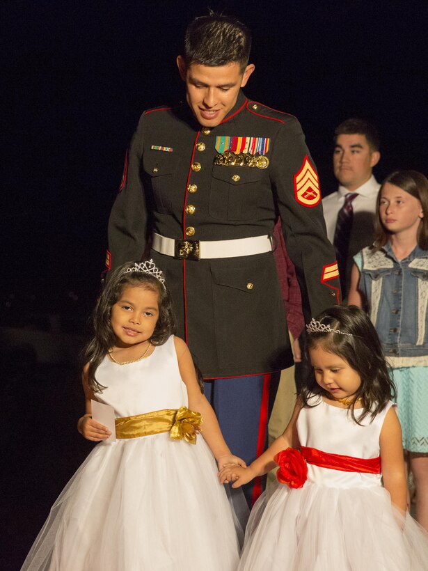 Staff Sgt. Guillermo Martinez, student, Marine Corps Communication-Electronics School, walks with his daughters during the Father Daughter Dance at Building 1707 Feb. 20, 2016. Marine Corps Community Services hosted the event to provide an opportunity for Marines and sailors to spend time with their daughters. (Official Marine Corps photo by Lance Cpl. Levi Schultz/Released)