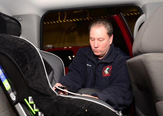 Mr. Jeff Akin, the 354th Civil Engineer Squadron emergency communications center supervisor, inspects a car seat Feb. 25, 2016, at Eielson Air Force Base, Alaska. During the inspection, the car seat is checked for proper installation and expiration date. (U.S. Air Force photo by Staff Sgt. Joshua Turner/Released)