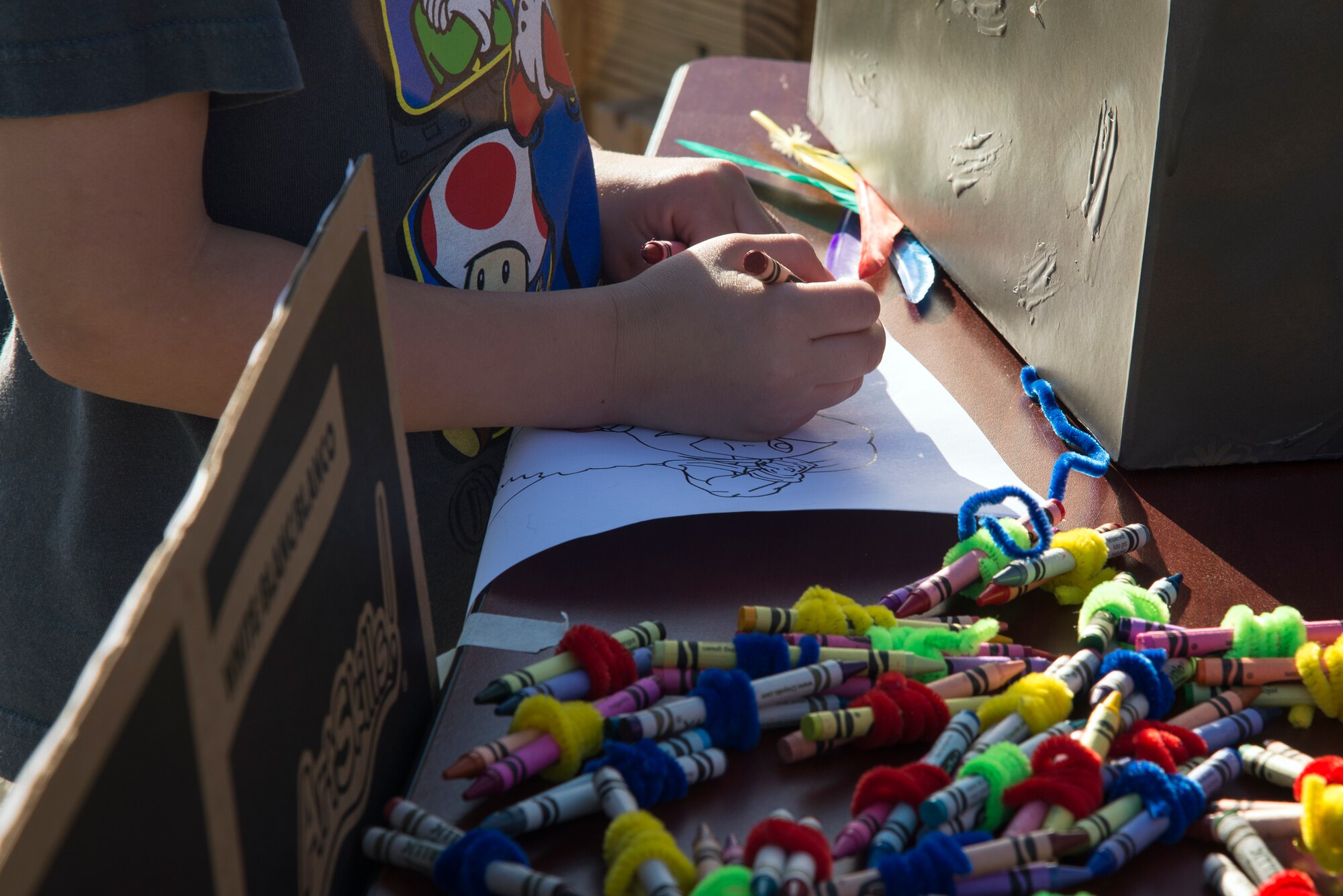 A child colors a picture of a cyclops during the Literacy Fair, Feb. 23, 2016, at Moody Air Force Base, Ga. A story from Homer’s Odyssey, which was read to participants, featured the cyclops and was brought to life by volunteers from a local English class. (U.S. Air Force photo by Airman 1st Class Janiqua P. Robinson/Released)