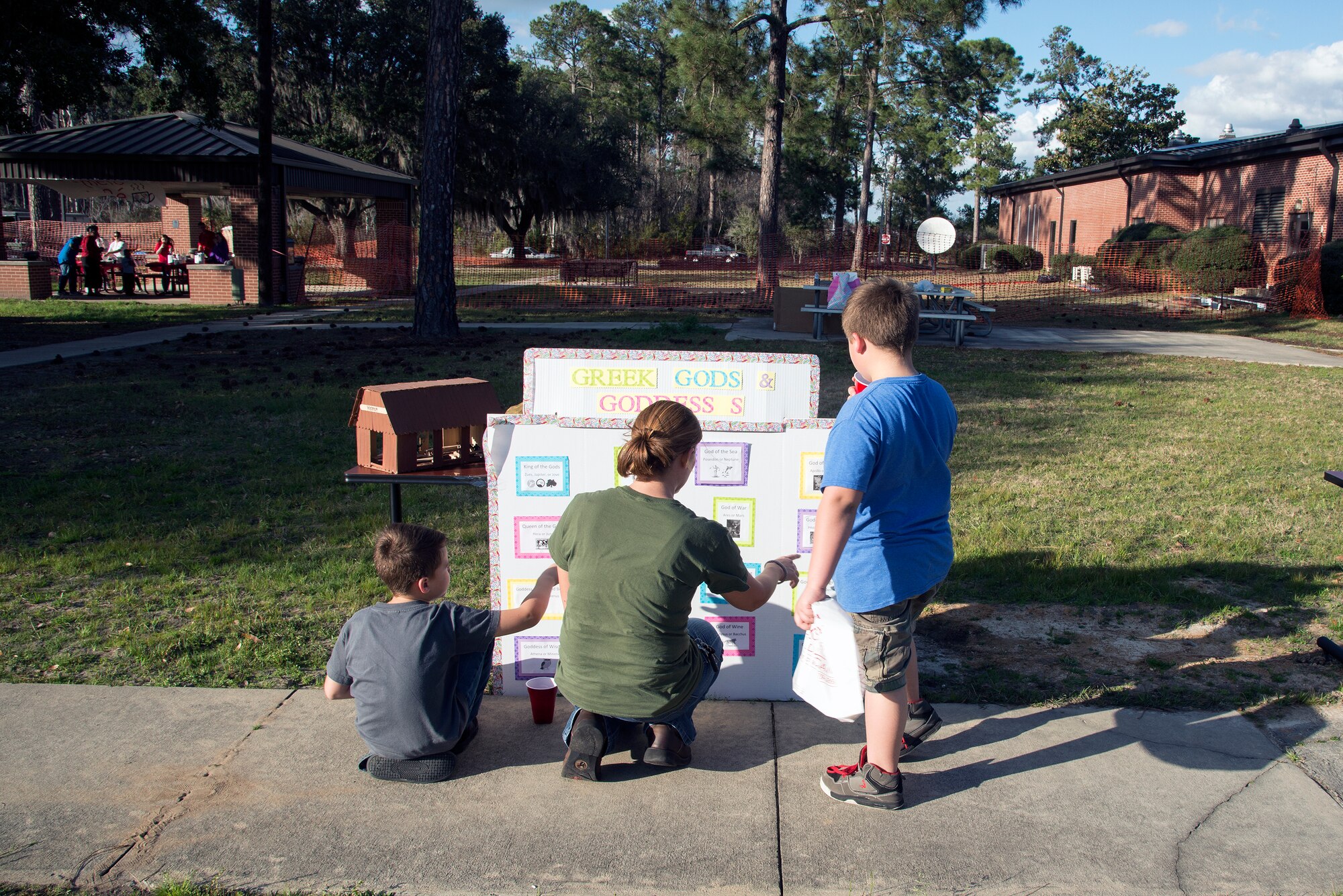 A family looks at a presentation board that highlights mythical Greek gods and goddesses during the Literacy Fair, Feb. 23, 2016, at Moody Air Force Base, Ga. The literacy fair featured various stations that told stories from Greek mythology. (U.S. Air Force photo by Airman 1st Class Janiqua P. Robinson/Released)
