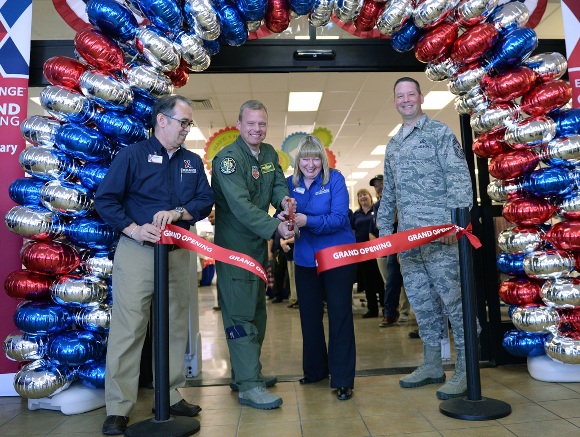Charlie Marshall (left), base exchange store manager, Col Christopher Stricklin, 9th Reconnaissance Wing vice commander, Mary Omler, BX general manager, and Chief Master Sgt. Randy Kwiatkowski (right), 9th RW command chief, cut the ribbon at Beale Air Force Base Exchange grand reopening Feb. 25, 2016. The approximate $1.9 million project included new flooring, a floor plan to accommodate an expanded product line, new displays and a new central checkout location.