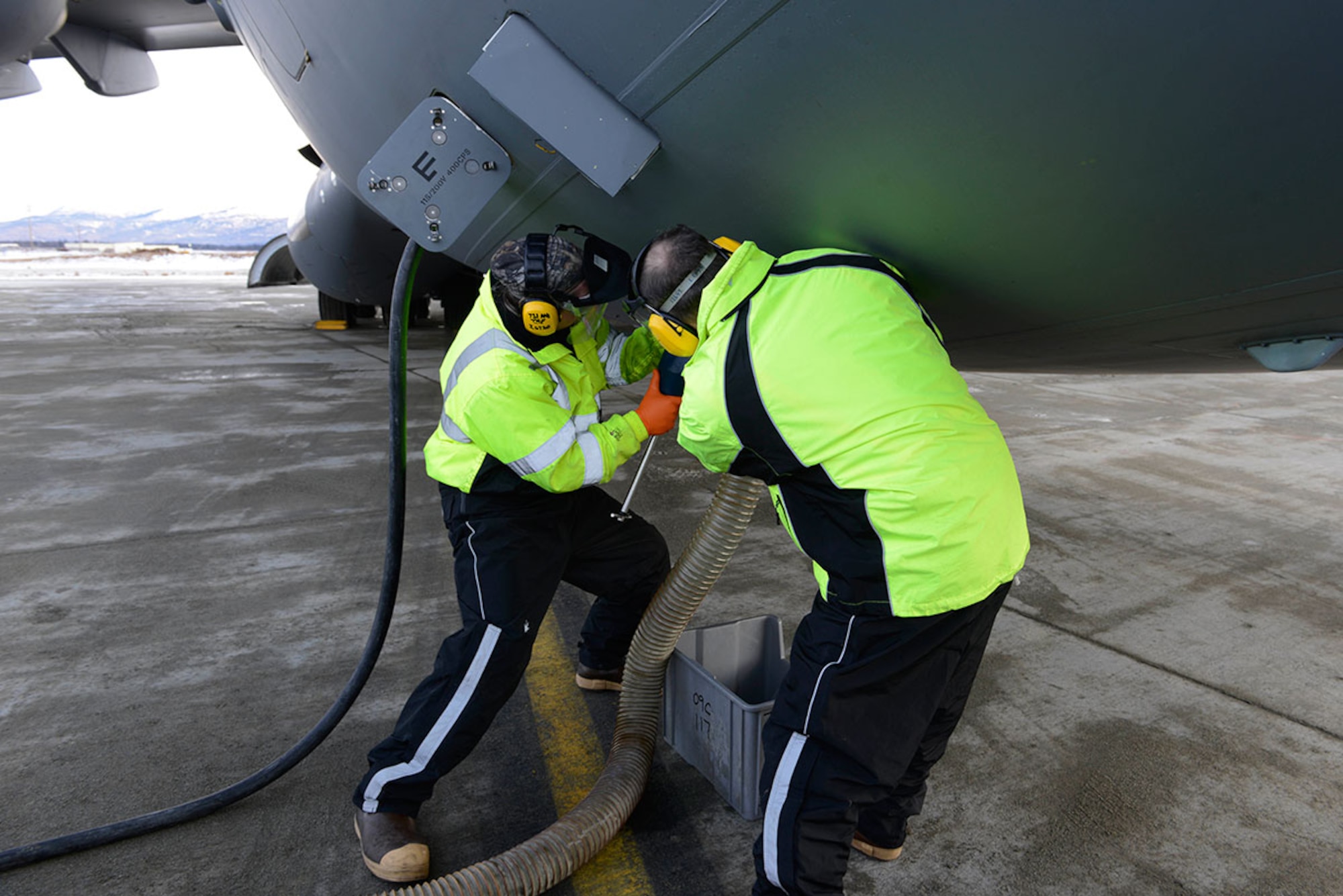 Jeffrey Zook, left, and Lewis Come, right, detach a drainage tube to a C-17 Globemaster III at Joint Base Elmendorf-Richardson, after removing the waste from the aircraft’s lavatory. Fleet services not only cleans and services all aircraft lavatories, but also removes trash on board and prepares all outbound aircraft with pillows, blankets and other necessary items. Zook is a fleet services vehicle operator and Come is the fleet services supervisor, both are with the 732nd Air Mobility Squadron. (U.S. Air Force photo by Airman Valerie Monroy)