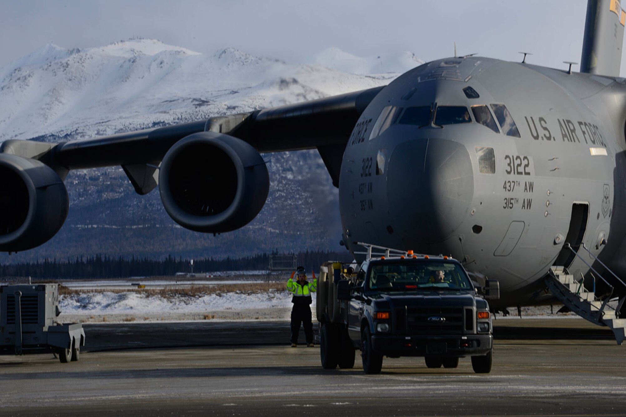 Jeffrey Zook, 732nd Air Mobility Squadron fleet services vehicle operator, guides one of the latrine servicing trucks safely toward a C-17 Globemaster III at Joint Base Elmendorf-Richardson. Fleet services ensures all aircraft, regardless of origin, are clean and serviceable for aircrews and passengers. (U.S. Air Force photo by Airman Valerie Monroy)