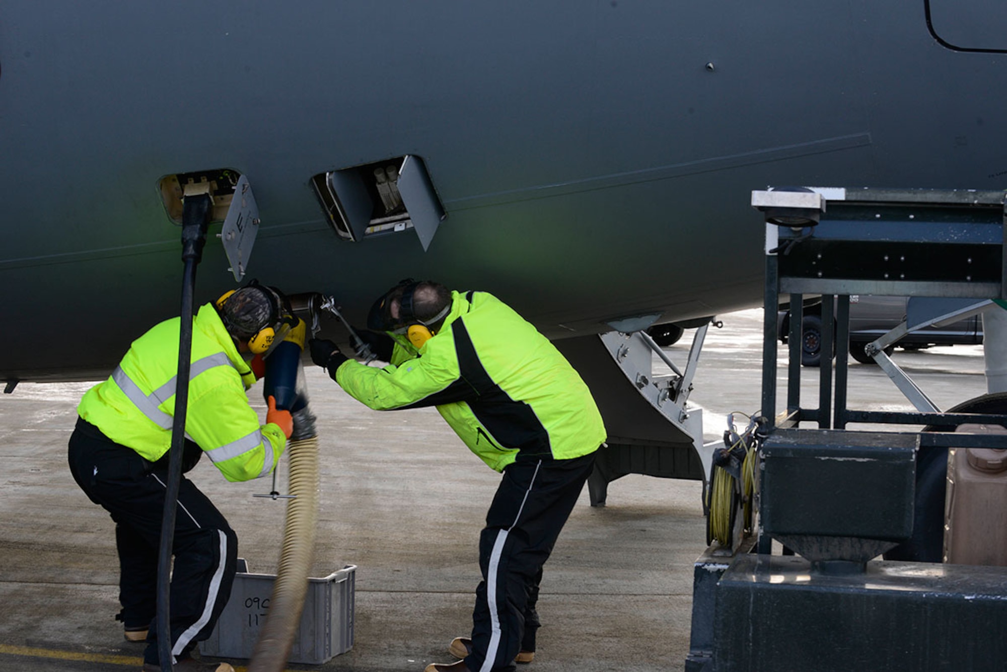 Jeffrey Zook, left, and Lewis Come, right, attach a drainage tube to a C-17 Globemaster III at Joint Base Elmendorf-Richardson, to remove the waste from the aircraft’s lavatory. Fleet services not only cleans and services all aircraft lavatories, but also removes trash on board and prepares all outbound aircraft with pillows, blankets and other necessary items. Zook is a fleet services vehicle operator and Come is the fleet services supervisor, both are with the 732nd Air Mobility Squadron. (U.S. Air Force photo by Airman Valerie Monroy)