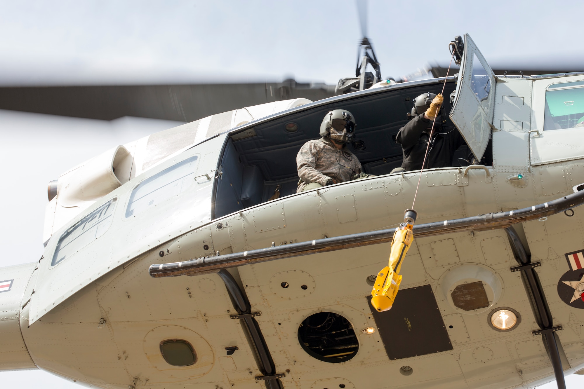 (Left to right) Tech. Sgt. Michael Wright, 459th Airlift Squadron flight engineer and Tech. Sgt. Christopher Pound, 36th Rescue Squadron special missions aviator evaluator, perform hoist training at Yokota Air Base, Japan, Feb. 22, 2016. The 459 AS recently improved their search and rescue capabilities by outfitting two UH-1N Hueys with new rescue hoists. Previously, without the hoist, conducting rescues in small, tight areas wasn’t feasible. Now, 459 AS aircrew can conduct any type of search and rescue scenario throughout the Kanto Plains. (U.S. Air Force photo by Osakabe Yasuo/Released)