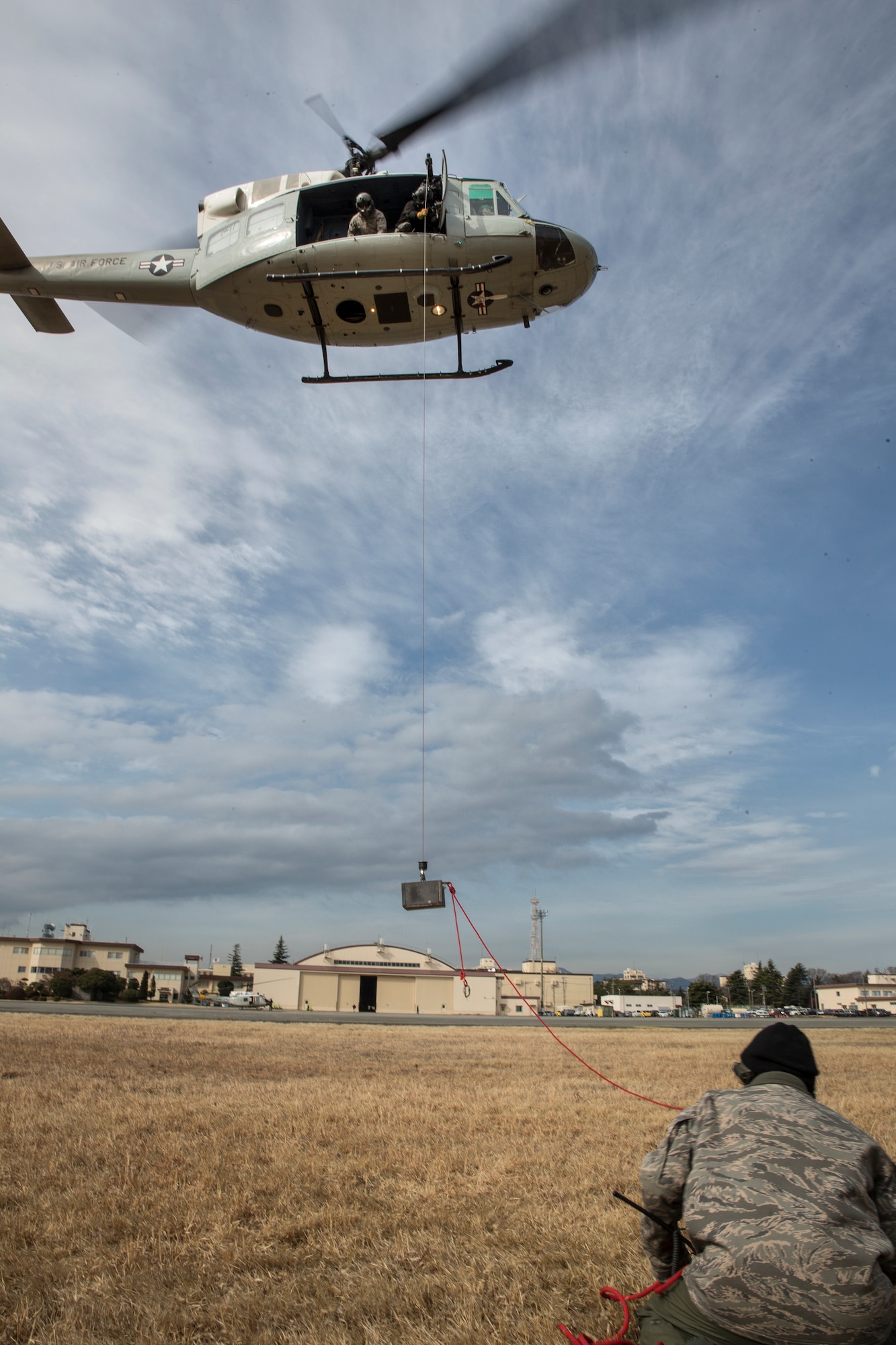 Members from the 459th Airlift Squadron perform hoist weight test at Yokota Air Base, Japan, Feb. 22, 2016. The 459 AS recently improved their search and rescue capabilities by outfitting two UH-1N Hueys with new rescue hoists. Previously, without the hoist, conducting rescues in small, tight areas wasn’t feasible. Now, 459 AS aircrew can conduct any type of search and rescue scenario throughout the Kanto Plains. (U.S. Air Force photo by Osakabe Yasuo/Released) 