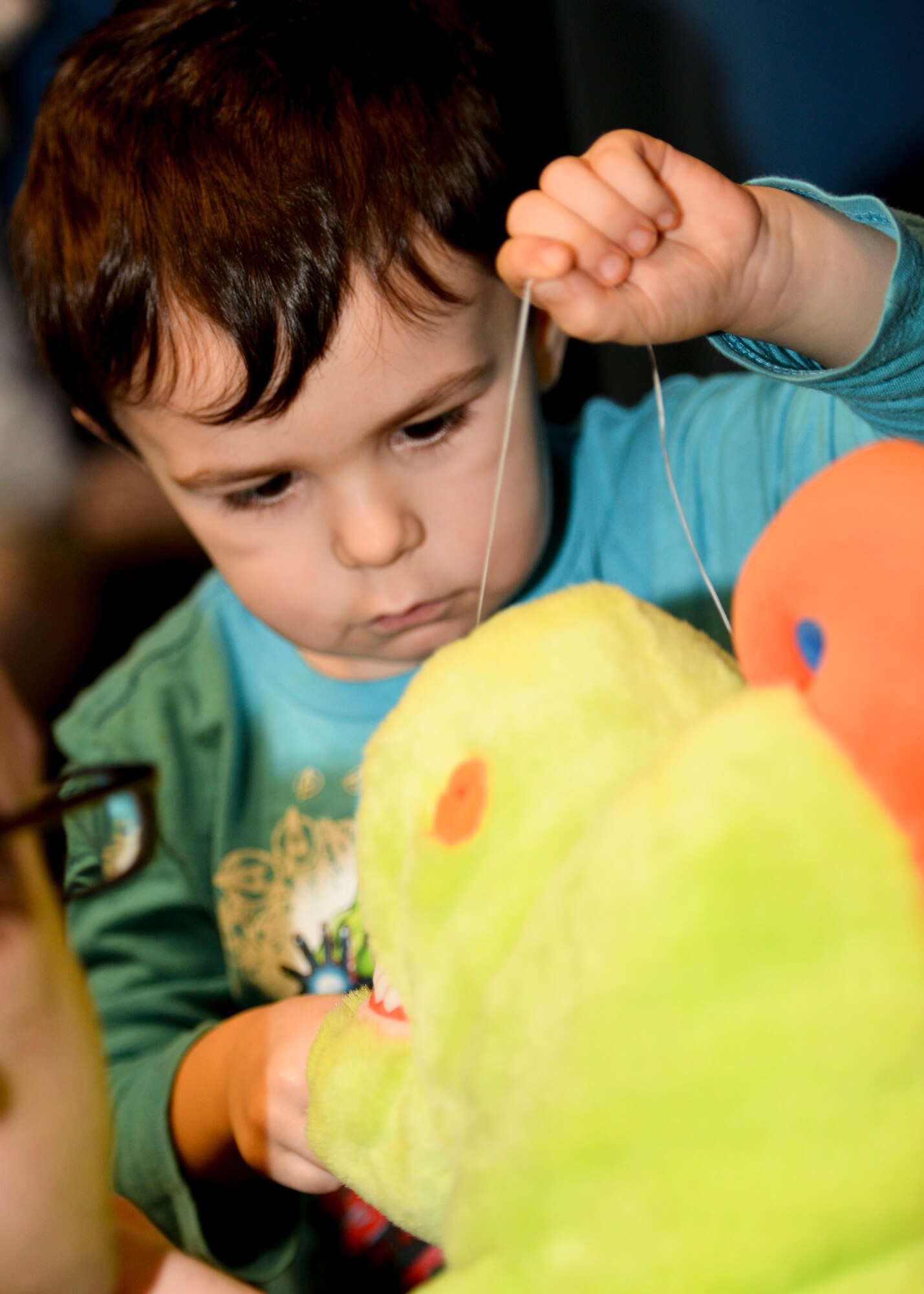 A child from Dakota Elementary flosses the teeth of a stuffed dinosaur at Minot Air Force Base, N.D., Feb. 18, 2016. The dinosaur was used during the dental health presentation given by 5th Medical Operations Squadron members to educate kids on dental hygiene practices during Children’s Dental Health Month. (U.S. Air Force photo/Airman 1st Class J.T. Armstrong)

