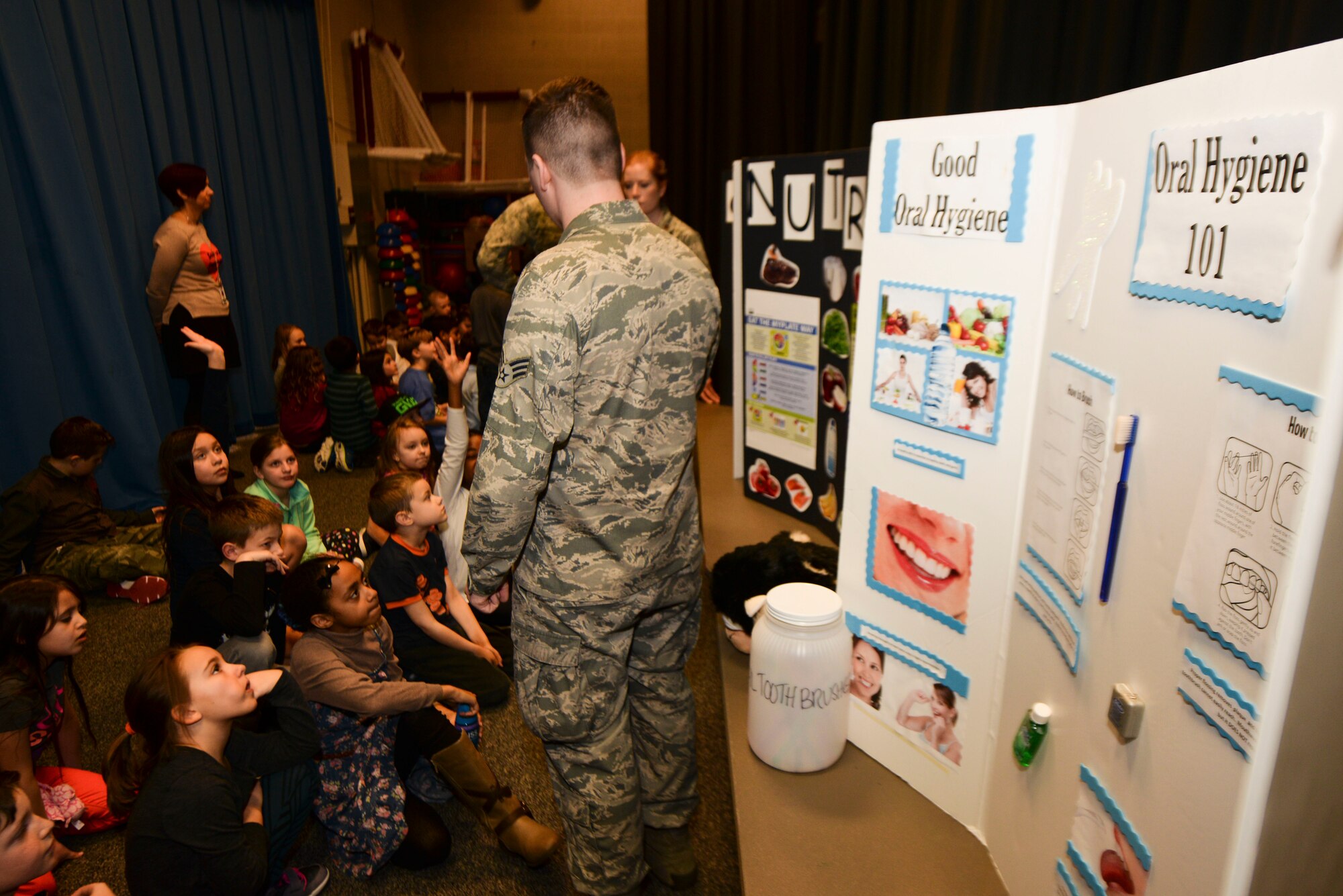 Senior Airman Stephen Clark, 5th Medical Operations Squadron dental technician, speaks to children about dental health during Children’s Dental Health Month at Minot Air Force Base, N.D., Feb. 18, 2016.  In addition to the presentation, children were given dental hygiene product kits with toothbrushes, toothpaste and floss. (U.S. Air Force photo/Airman 1st Class J.T. Armstrong)