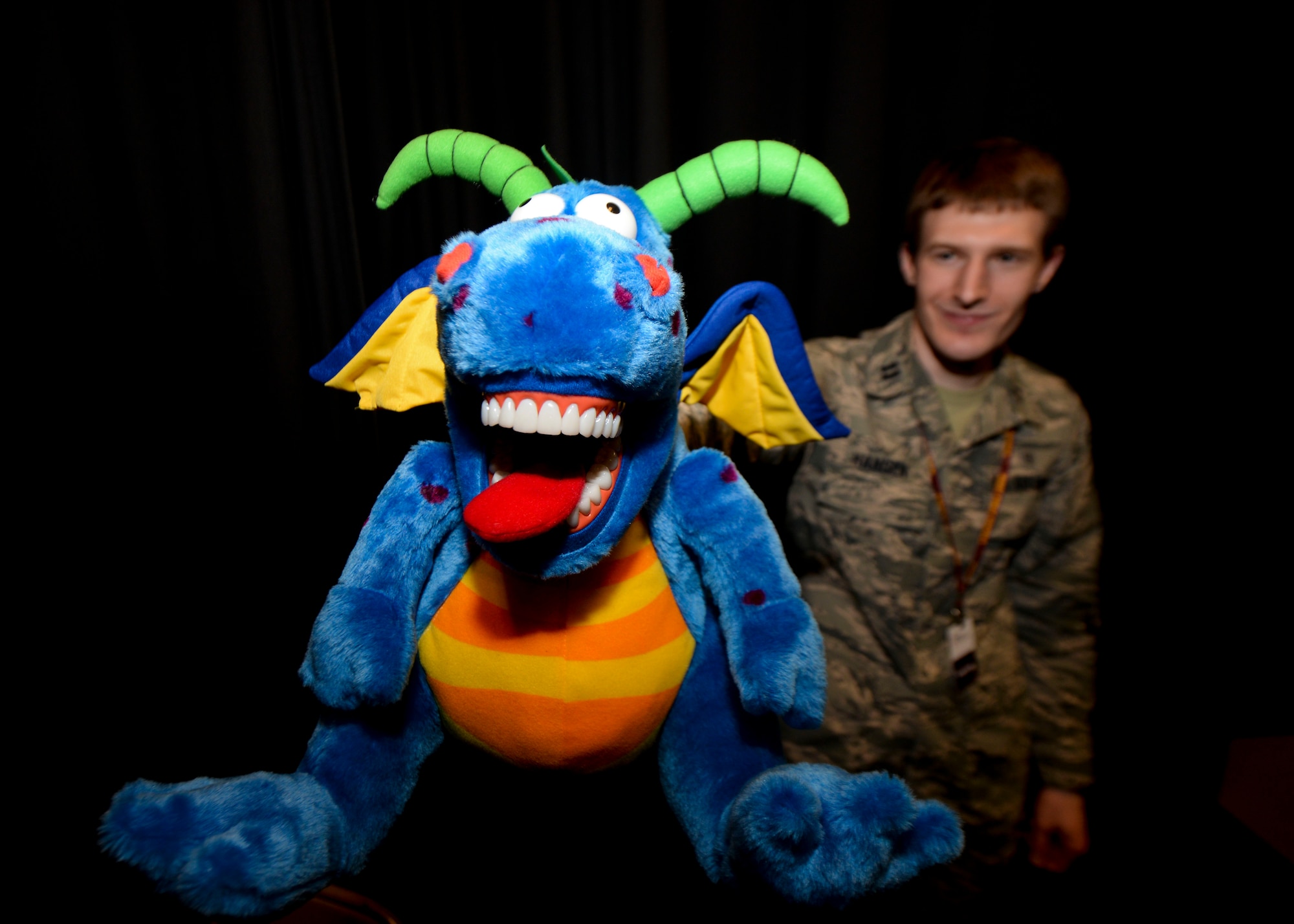 Capt. Curtis Hansen, 5th Medical Operations Squadron general dentist, holds a stuffed dragon at Dakota Elementary at Minot Air Force Base, N.D., Feb. 18, 2016. The dragon was used during the dental health presentation given by 5th MDOS members to educate kids on dental hygiene practices during Children’s Dental Health Month. (U.S. Air Force photo/Airman 1st Class J.T. Armstrong)