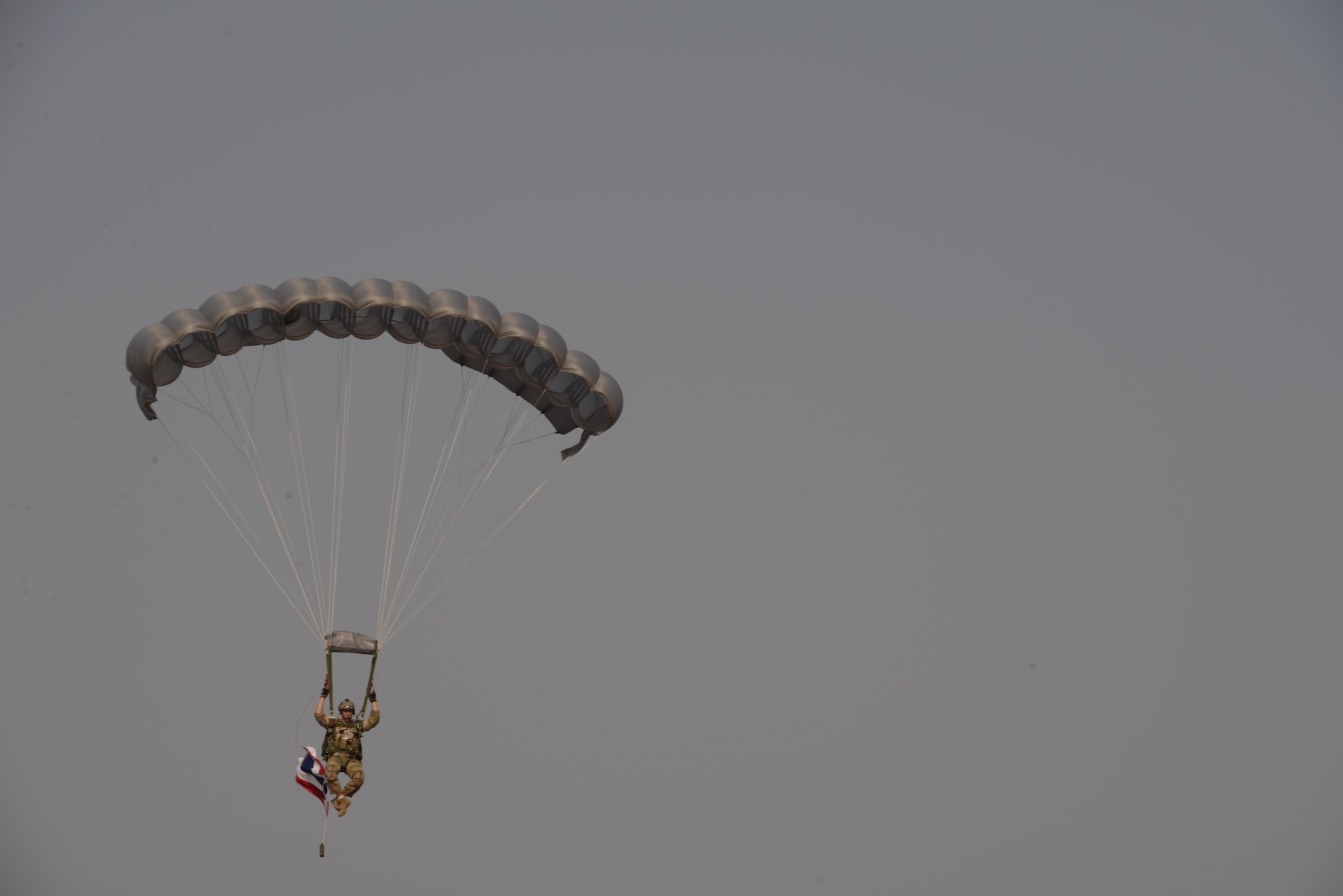 A member of the 320th Special Tactics Squadron parachutes out of an MC-130H with a Thailand flag from a military free fall jump during exercise Cobra Gold, Nam Phong, Thailand, Feb. 12, 2014. Working together, the U.S. and Thailand conducted combined task force training that is vital to maintaining the readiness and interoperability of security forces across the region. (U.S. Air Force photo by Senior Airman Stephen G. Eigel)  