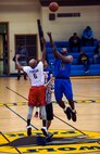 Staff Sgt. Kendell Grant, Agency power forward and 8th Comptroller Squadron unit deployment manager, battles for the ball with Staff Sgt. Chukwudi Ekeh, Defenders center and 8th Security Forces Squadron response force leader, during the tip off of an intramural basketball championship at Kunsan Air Base, Republic of Korea, Feb. 26, 2016. The Defenders beat the Agency  75-39. (U.S. Air Force photo by Staff Sgt. Nick Wilson/Released)
