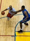 Staff Sgt. Kendell Grant, Agency power forward and 8th Comptroller Squadron unit deployment manager, drives the ball as Staff Sgt. Chukwudi Ekeh, Defenders center and 8th Security Forces Squadron response force leader, plays defense during an intramural basketball championship at Kunsan Air Base, Republic of Korea, Feb. 26, 2016. The Defenders beat the Agency 75-39. (U.S. Air Force photo by Staff Sgt. Nick Wilson/Released)