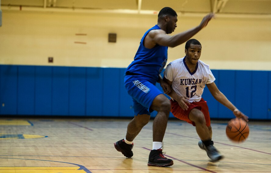 Staff Sgt. Chukwudi Ekeh, Defenders center and 8th Security Forces Squadron response force leader, plays tight defense as Staff Sgt. Clintin Carter, Agency point guard and 8th Fighter Wing Staff knowledge operations craftsman, drives the ball during an intramural basketball championship at Kunsan Air Base, Republic of Korea, Feb. 26, 2016. The Defenders beat the Agency 75-39. (U.S. Air Force photo by Staff Sgt. Nick Wilson/Released)